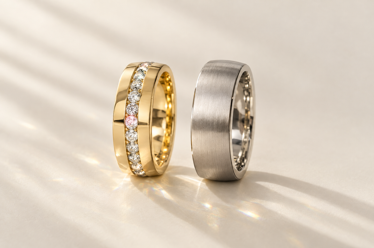 Men's diamond wedding band in yellow gold beside a brushed white gold band