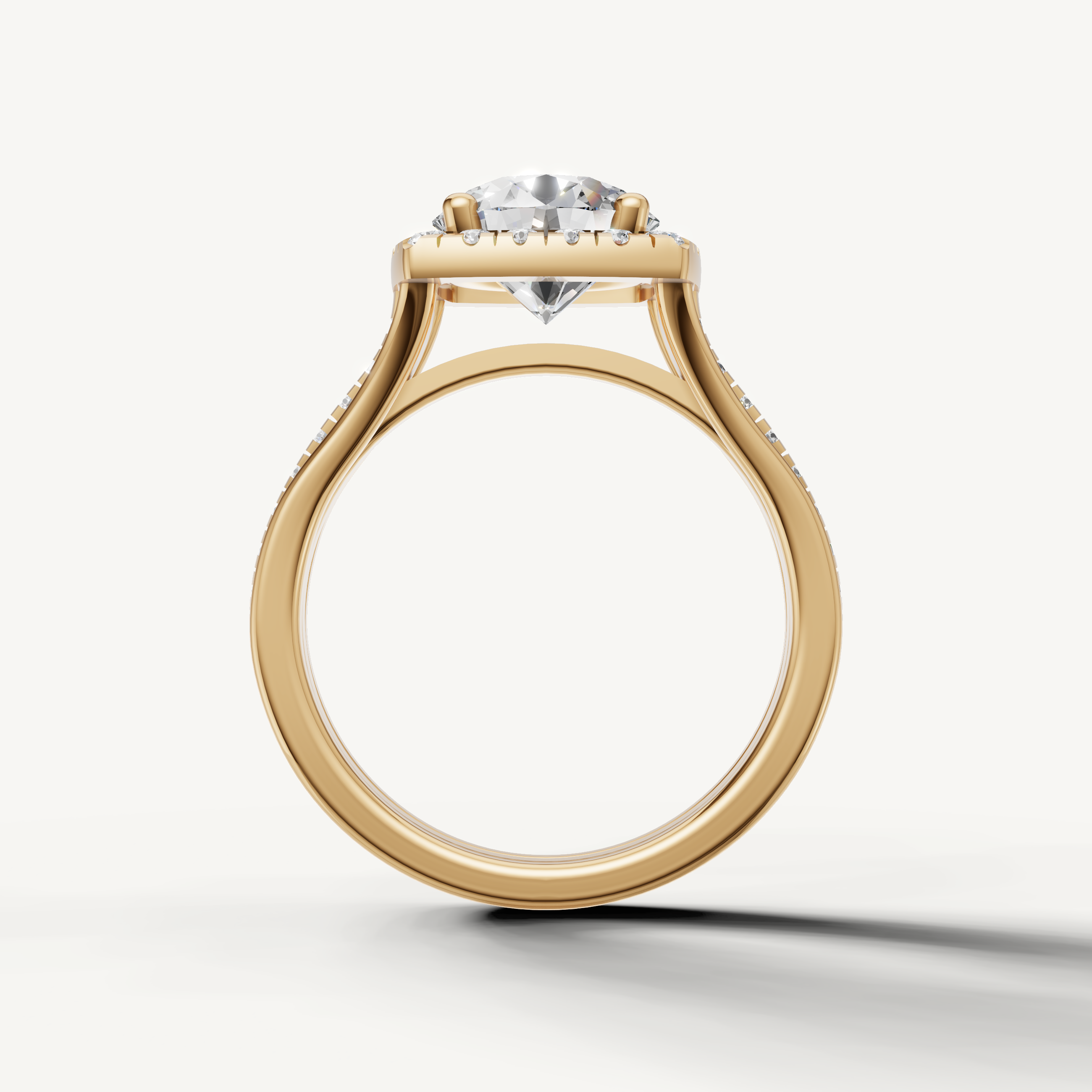Round cut diamond halo ring with split shank band in yellow gold from Raul Diamonds.