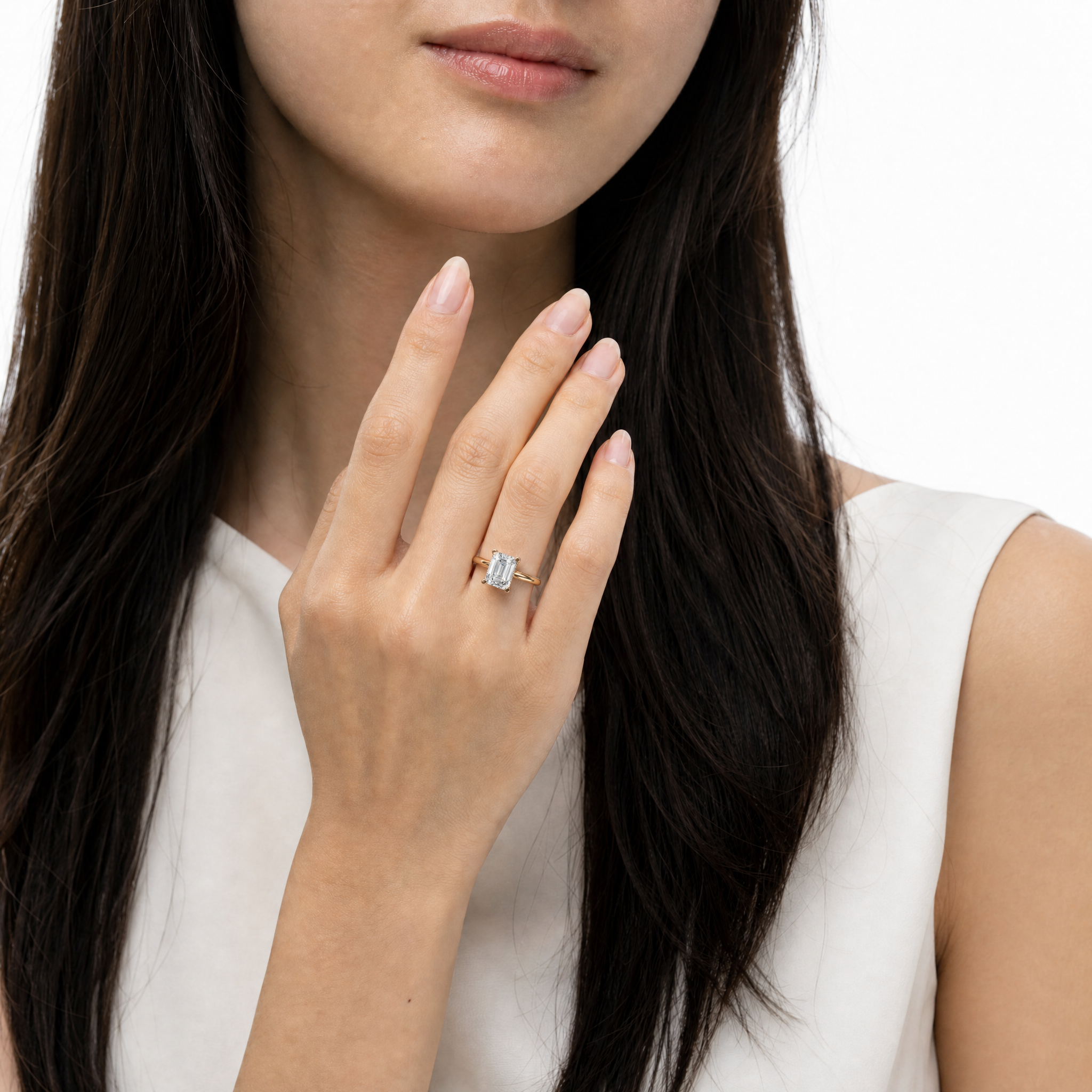 High-fashion model Adriana Moretti wearing a signature Raul Diamonds emerald cut engagement ring, showcasing the elegant rectangular facets and sophisticated gold band.