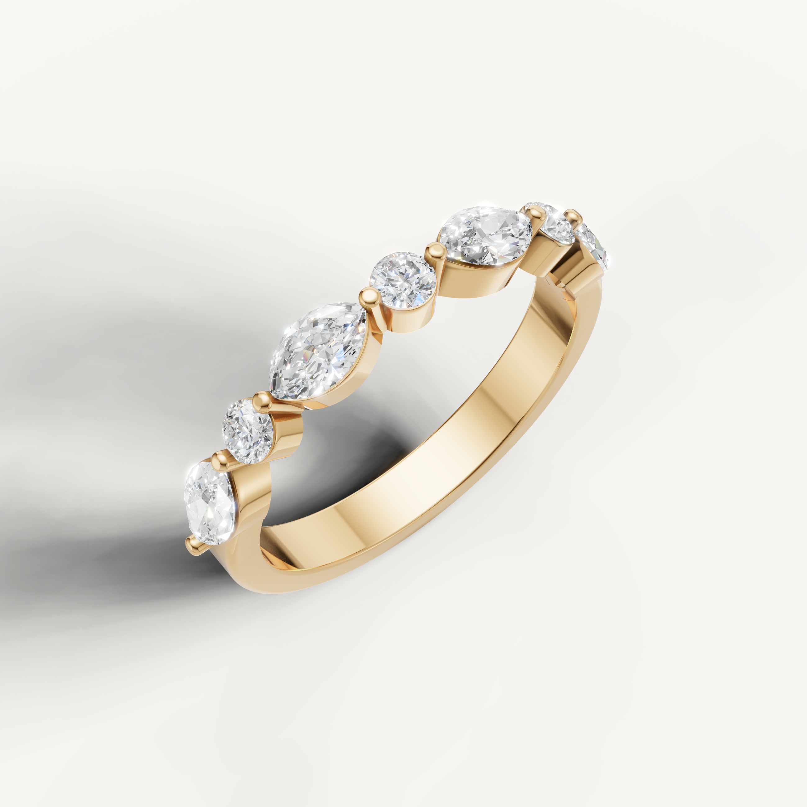 Elegant yellow gold diamond wedding band by Raul Diamonds featuring alternating pear and round brilliant stones