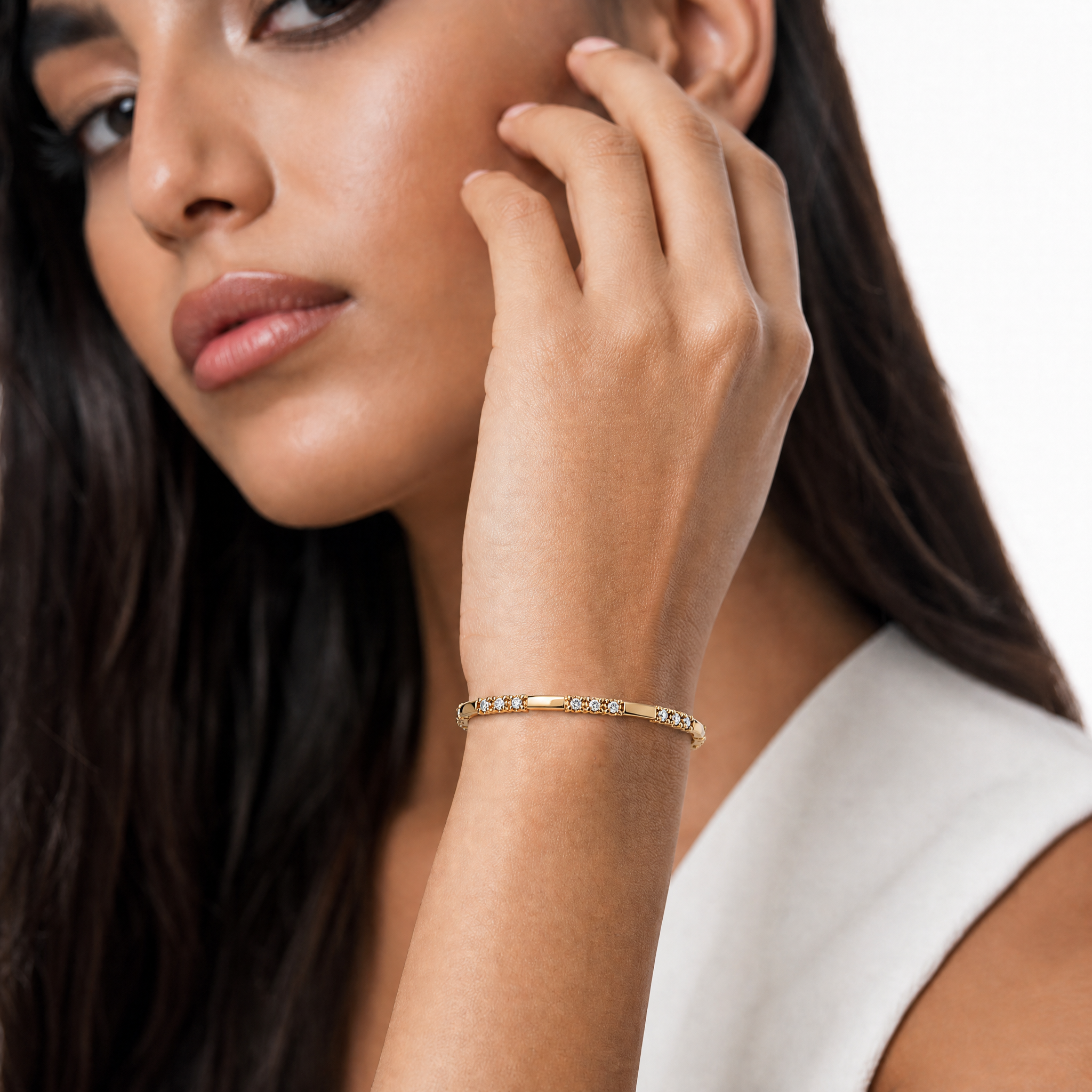 Elegant female model wearing a luxury lab grown diamond bracelet in yellow gold by Raul Diamonds with timeless fine jewelry styling and modern sophistication