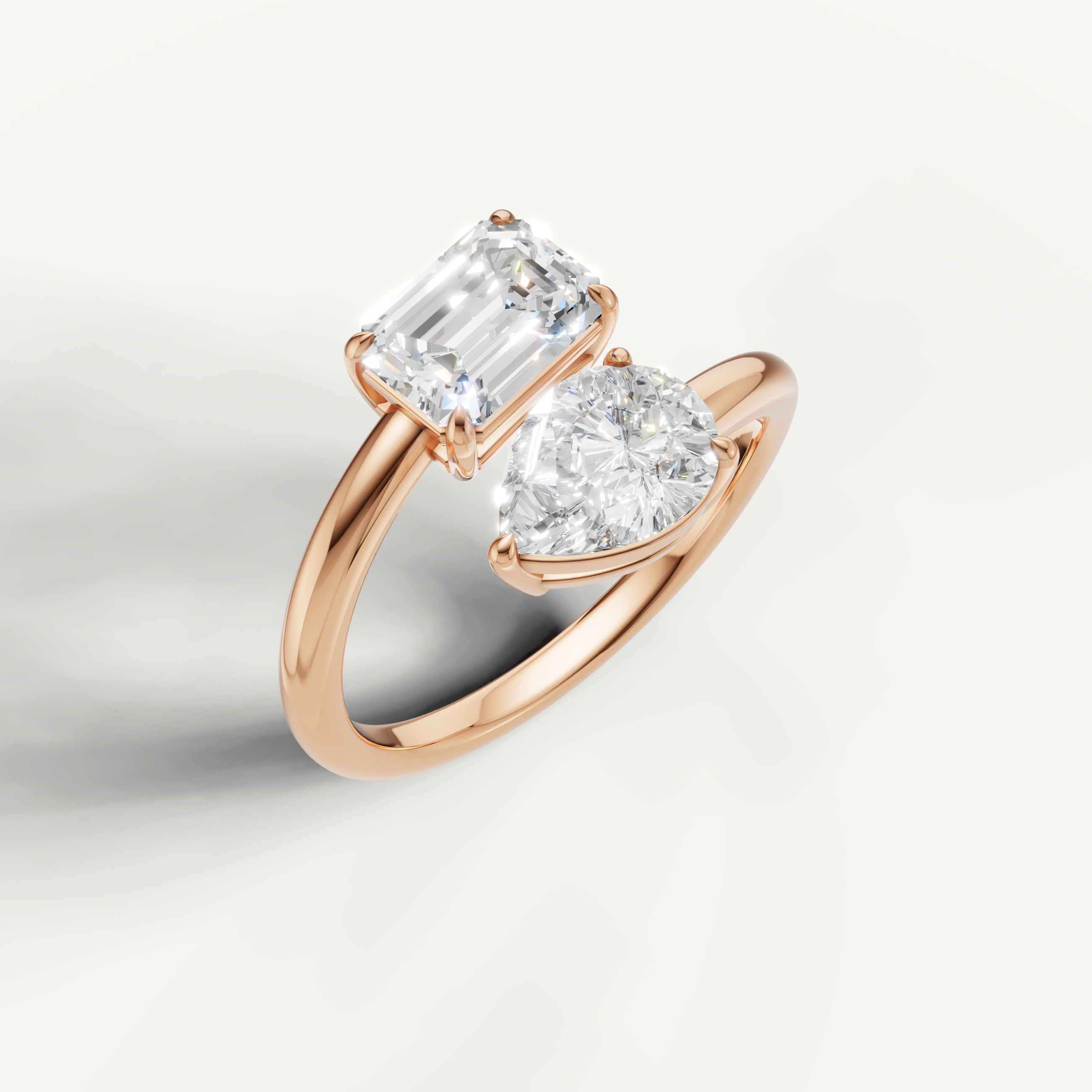 Contemporary rose gold open ring with pear and emerald cut diamond setting by Raul Diamonds