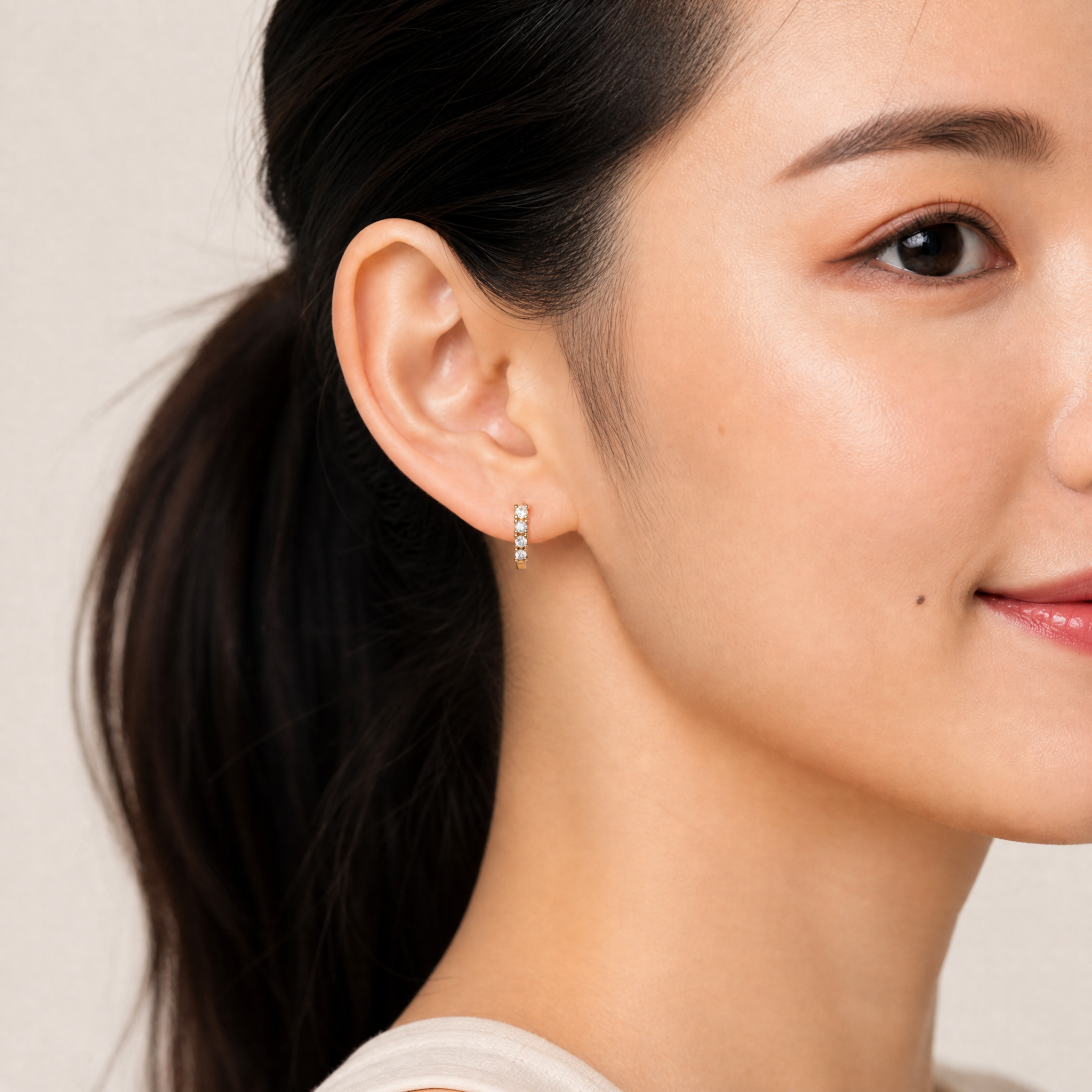 Elegant model wearing Raul Diamonds round diamond huggie hoop earrings with modern luxury style
