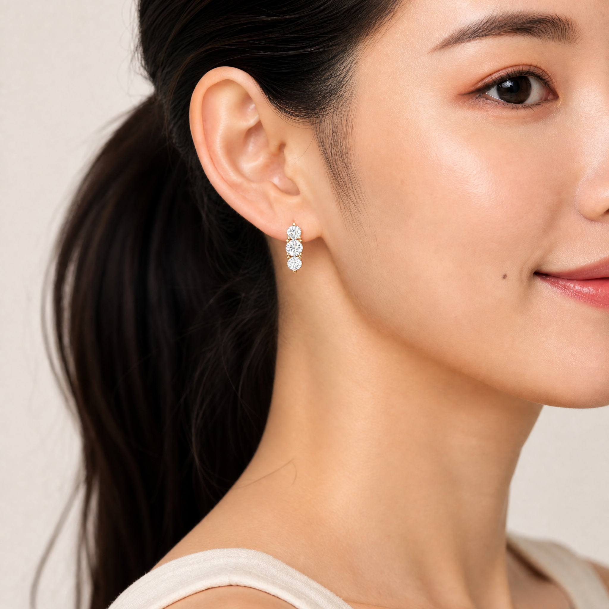 Elegant model wearing Raul Diamonds three stone diamond drop earrings with luxury sparkle