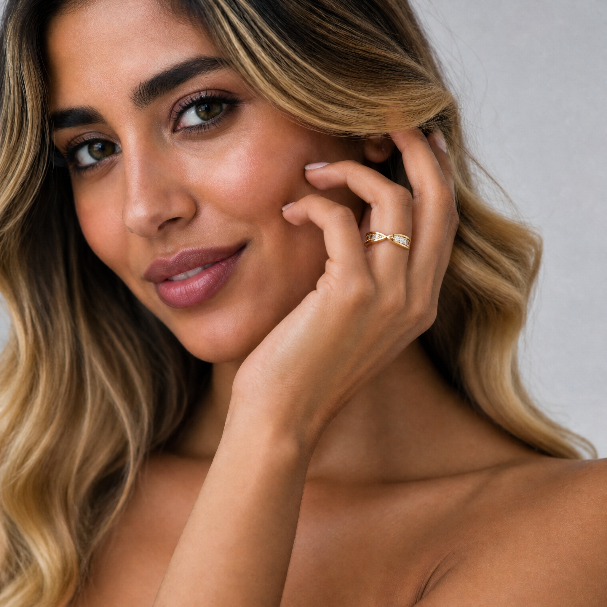 Female model wearing Raul Diamonds infinity crossover diamond wedding band in yellow gold with round brilliant diamonds