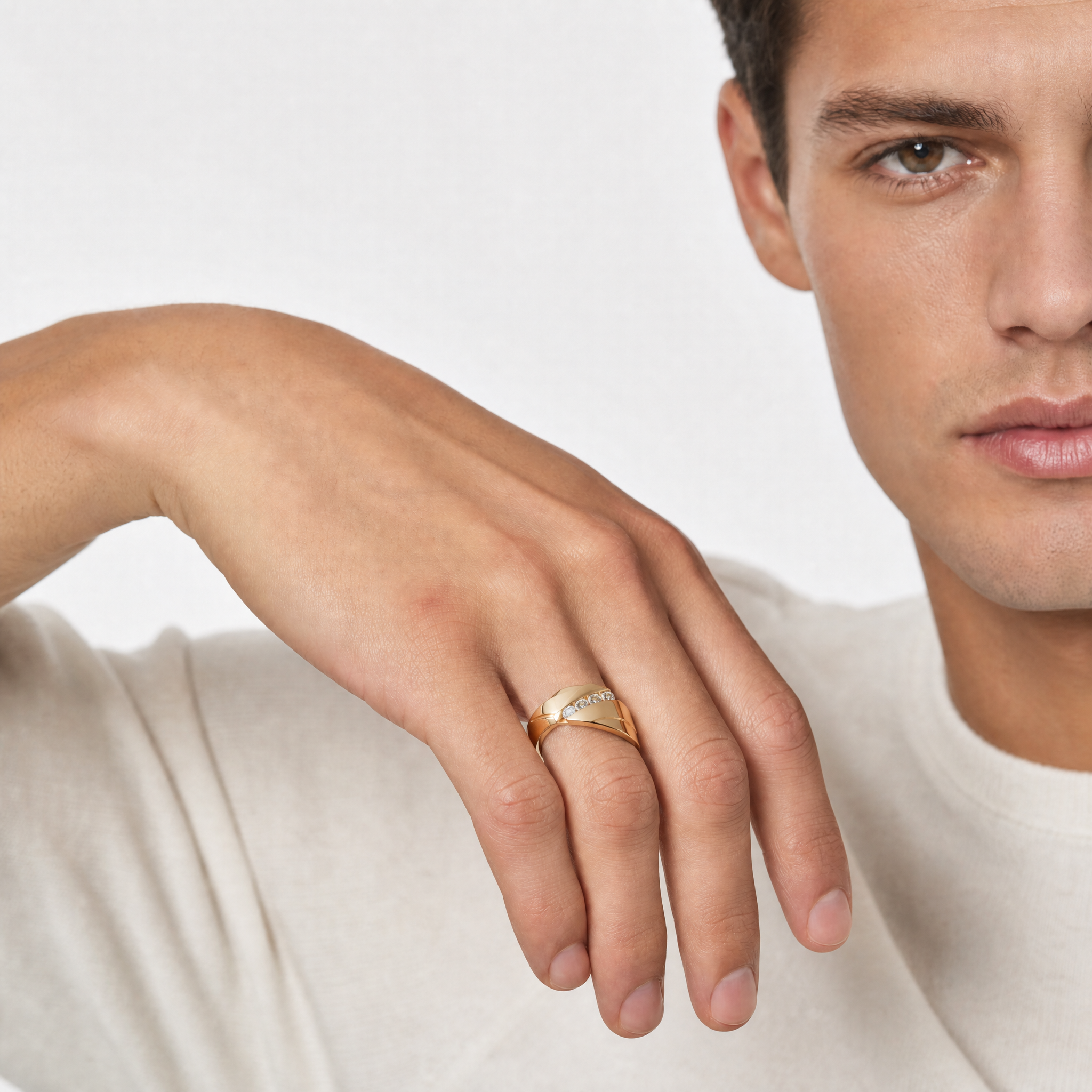 Male model wearing Raul Diamonds yellow gold diamond wedding ring with modern crossover band design and round diamonds