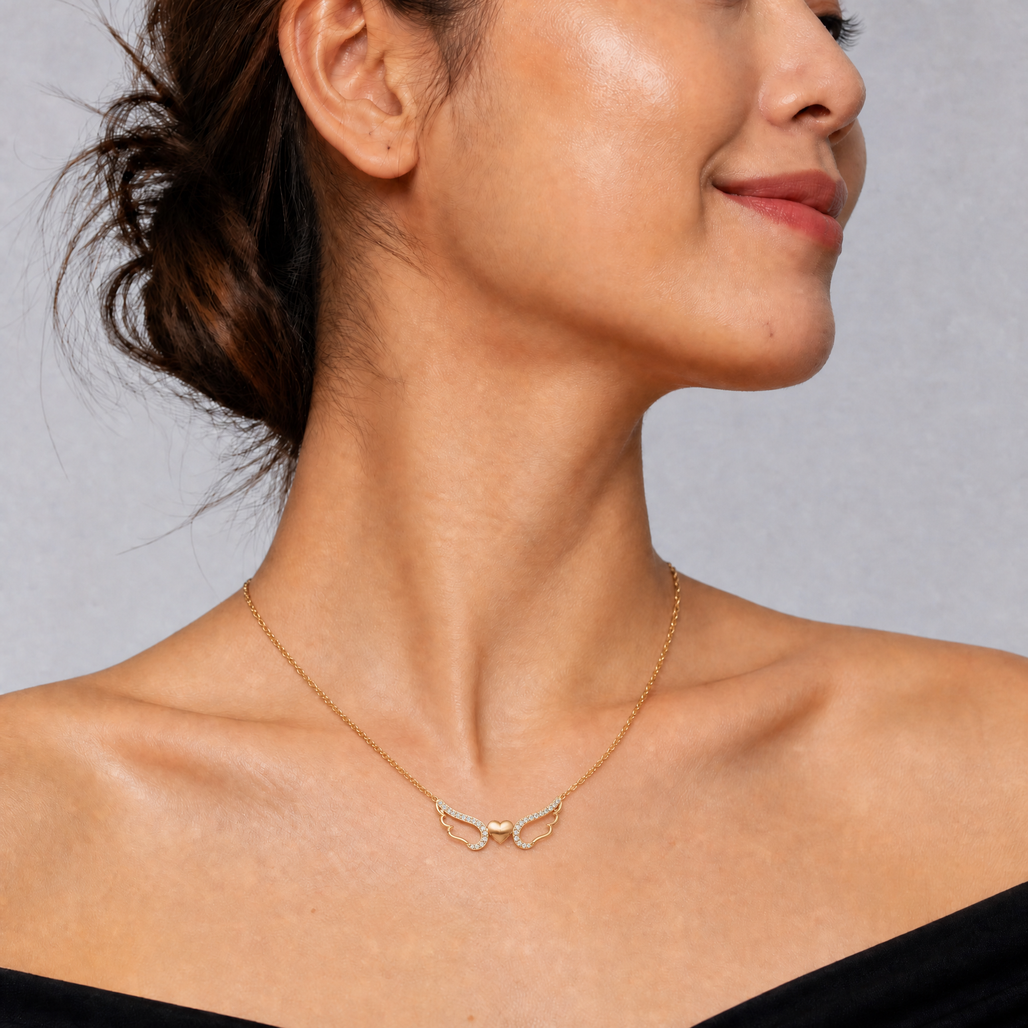 Model wearing Raul Diamonds yellow gold angel wing heart necklace with pavé lab grown diamonds and delicate luxury chain design