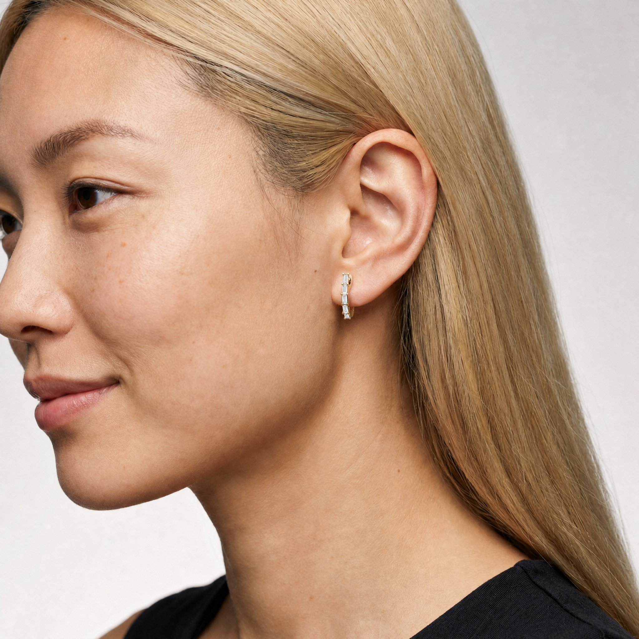 Model wearing Raul Diamonds yellow gold baguette cut lab grown diamond hoop earrings with sleek vertical diamond setting and modern luxury design