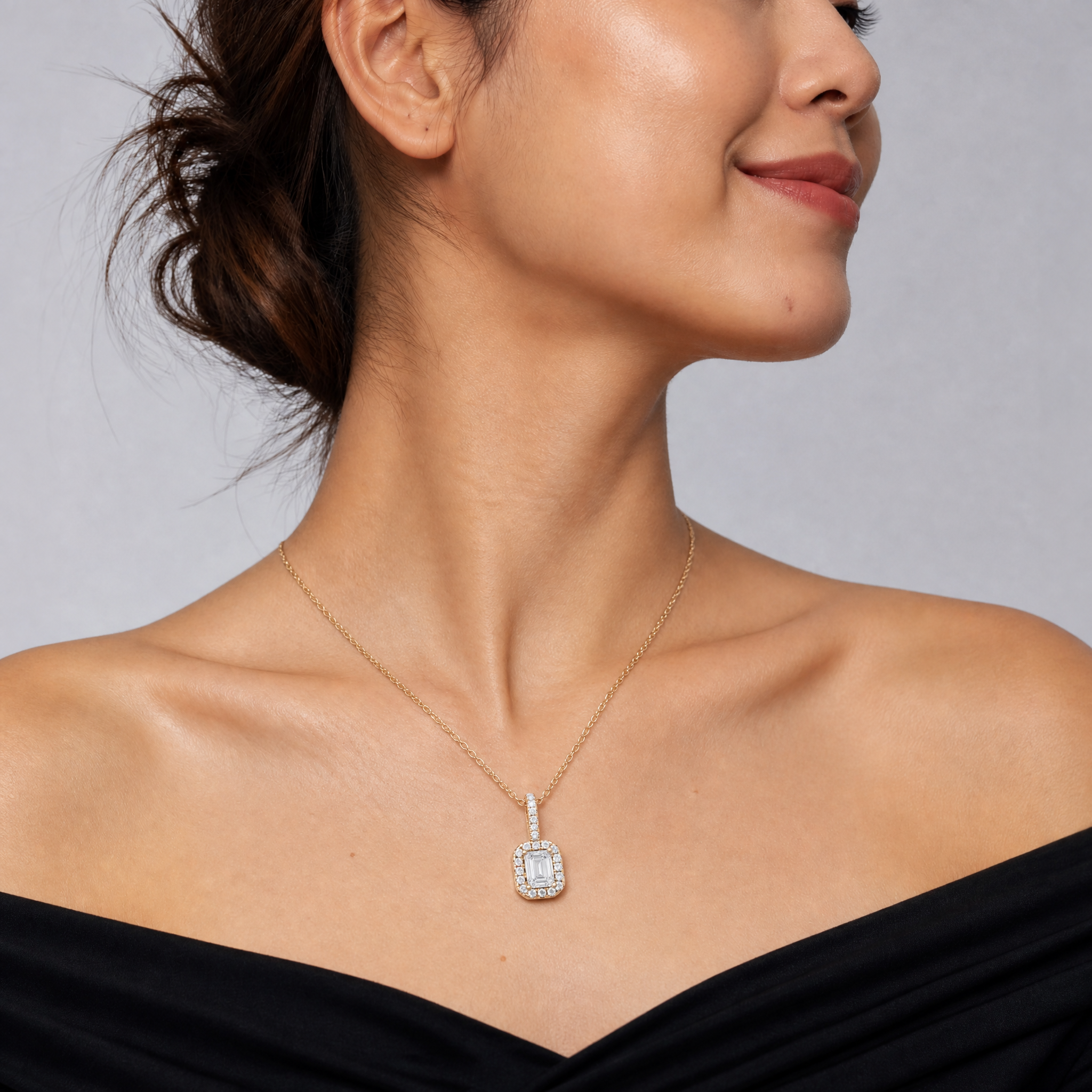 Model wearing Raul Diamonds yellow gold emerald cut lab grown diamond halo pendant necklace with pavé diamond detailing and delicate cable chain