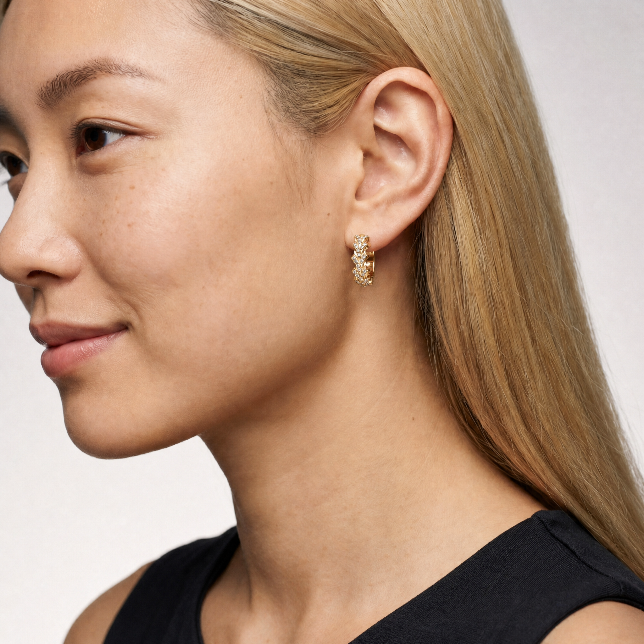 Model wearing Raul Diamonds yellow gold pavé lab grown diamond hoop earrings featuring geometric zig zag detailing and round brilliant diamonds