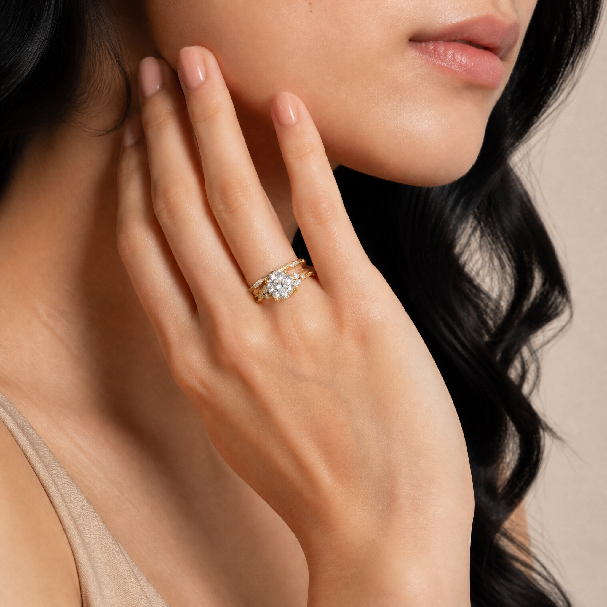 Model wearing Raul Diamonds yellow gold round cut lab grown diamond engagement ring with diamond accented curved wedding bands and marquise side stones