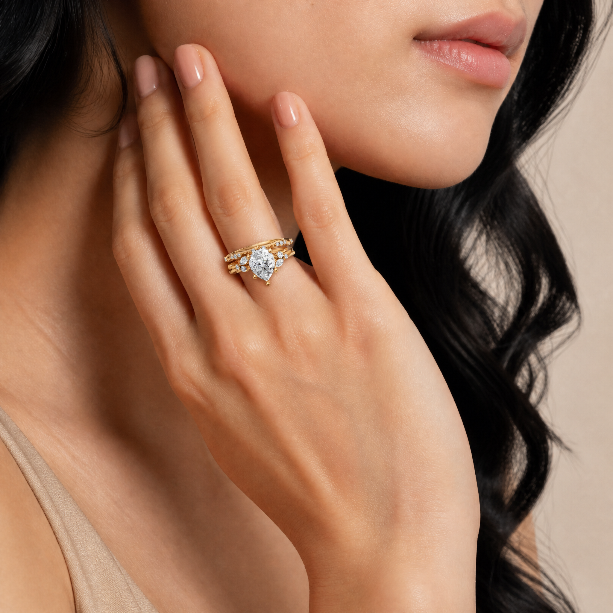 Model wearing Raul Diamonds yellow gold round lab grown diamond engagement ring with matching curved diamond wedding band and marquise accent details