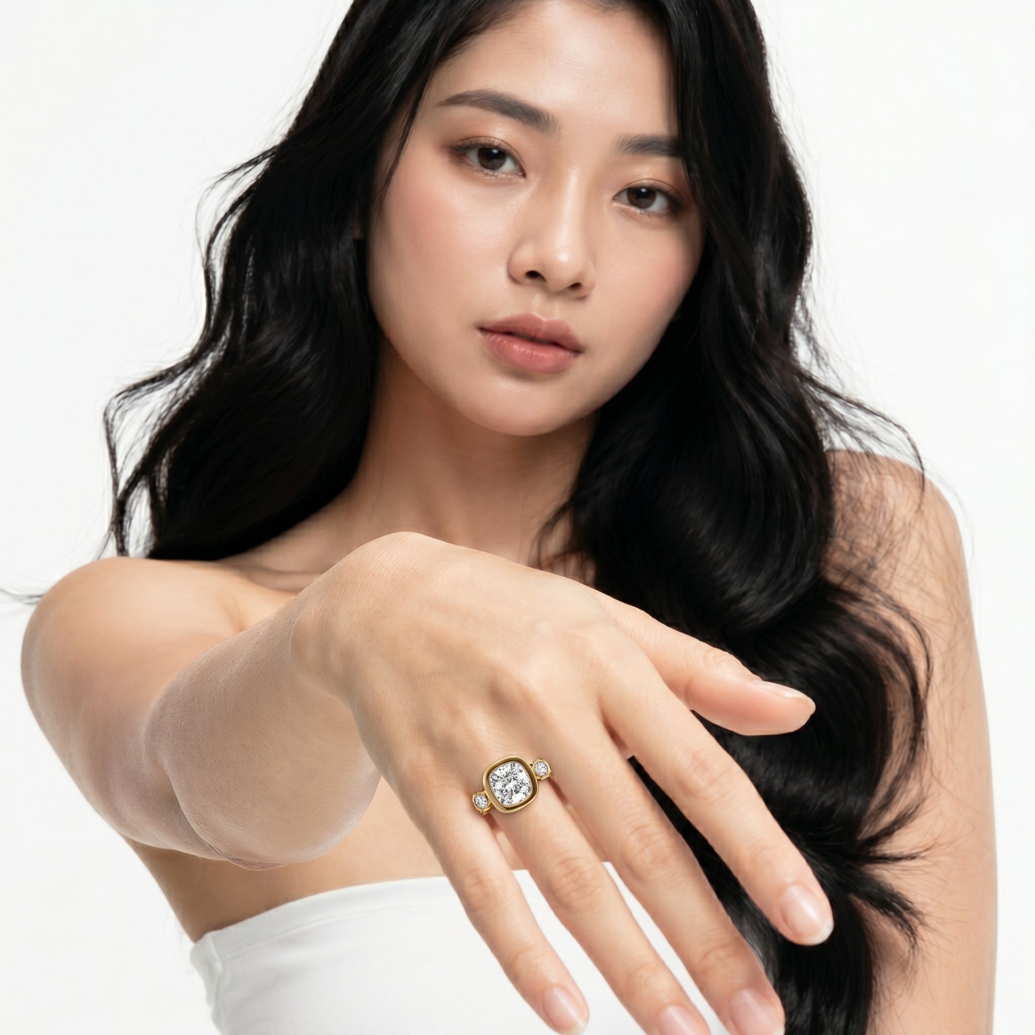 Model wearing the Seo bezel set diamond engagement ring from Raul Diamonds featuring a cushion center stone with side accent diamonds.