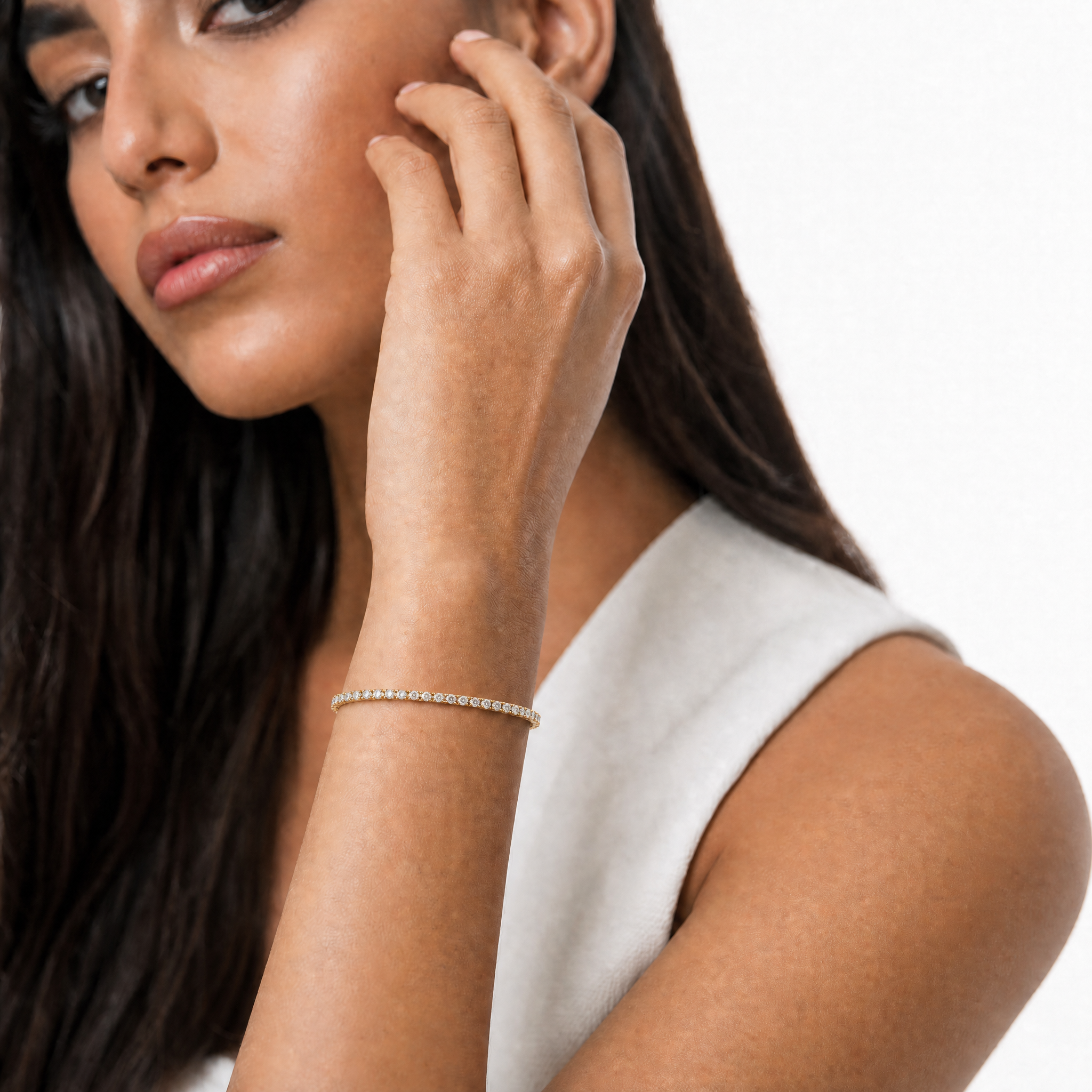 Luxury model wearing a 3 carat lab grown diamond tennis bracelet in yellow gold by Raul Diamonds with elegant wrist pose and premium fine jewelry styling