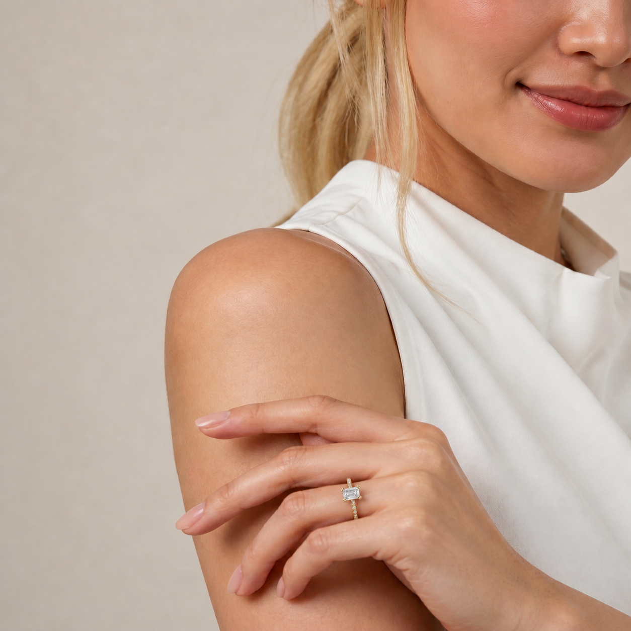 A lifestyle shot featuring the Celine Solitaire by Raul Diamonds, showcasing a premium emerald cut diamond center stone on a delicate diamond-encrusted pavé band.