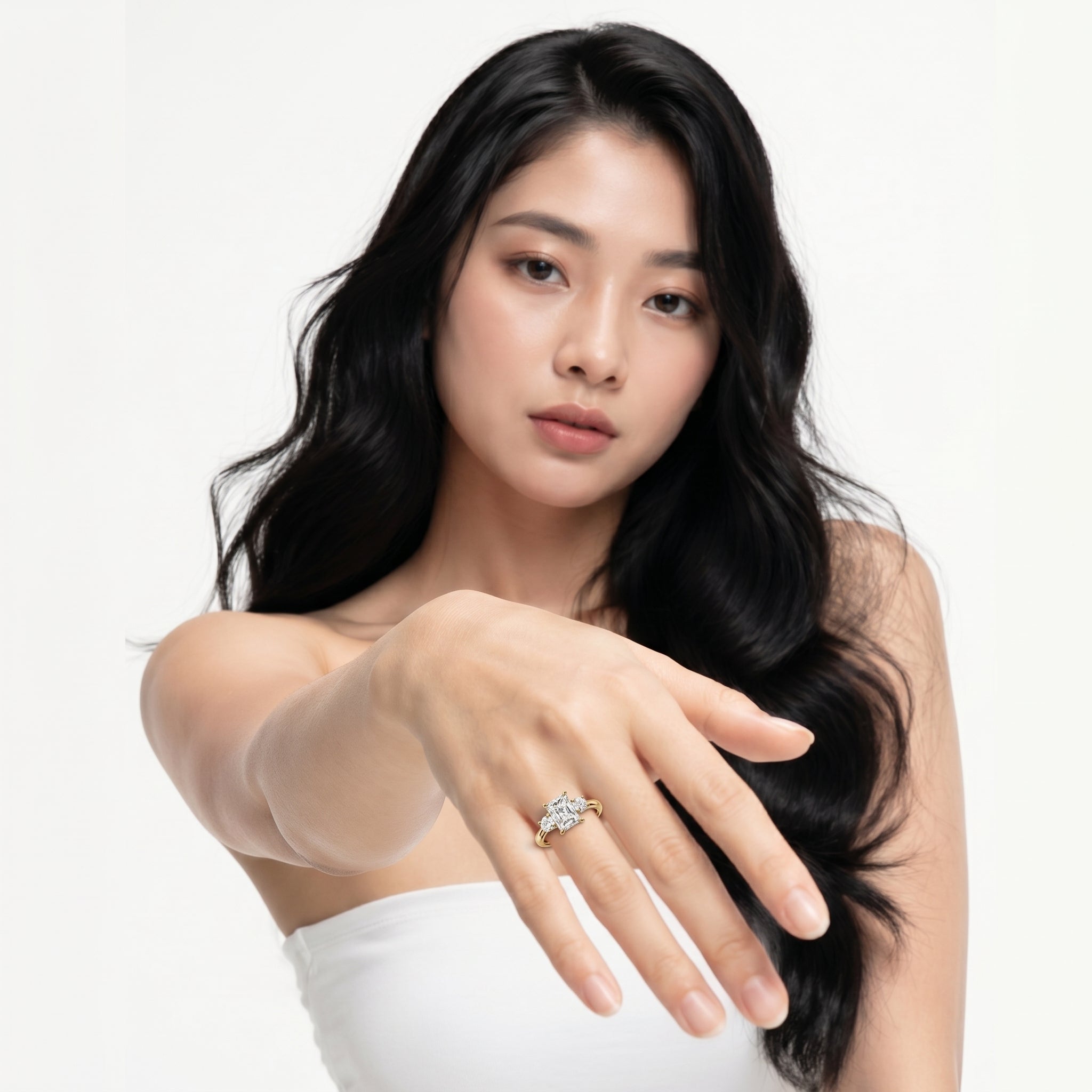 A professional lifestyle shot of the Valencia Trilogy ring by Raul Diamonds, featuring a large center radiant cut diamond flanked by two unique cadillac-shaped side diamonds on a high-polish gold band.