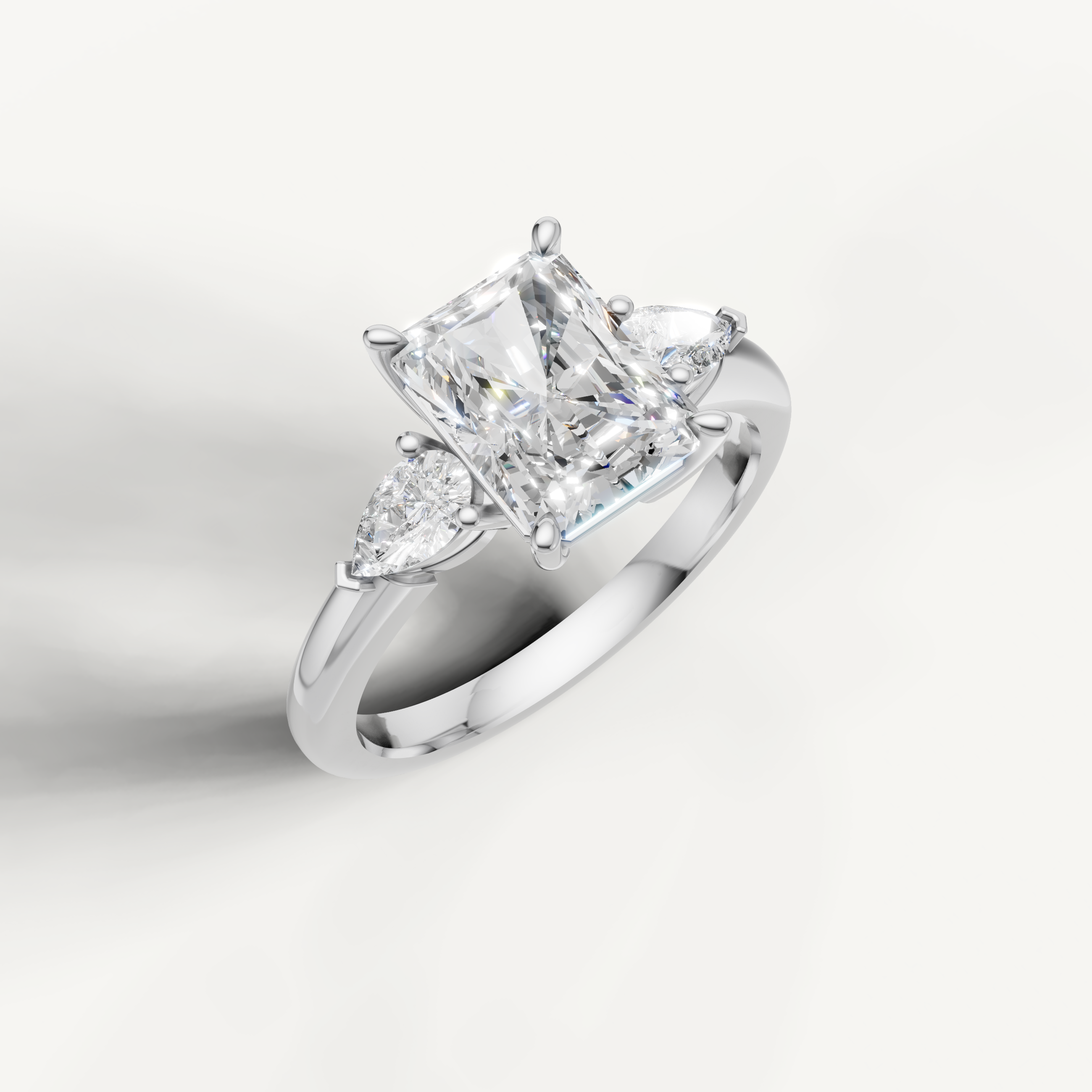 classic radiant cut lab grown diamond trilogy ring with pear shaped side stones