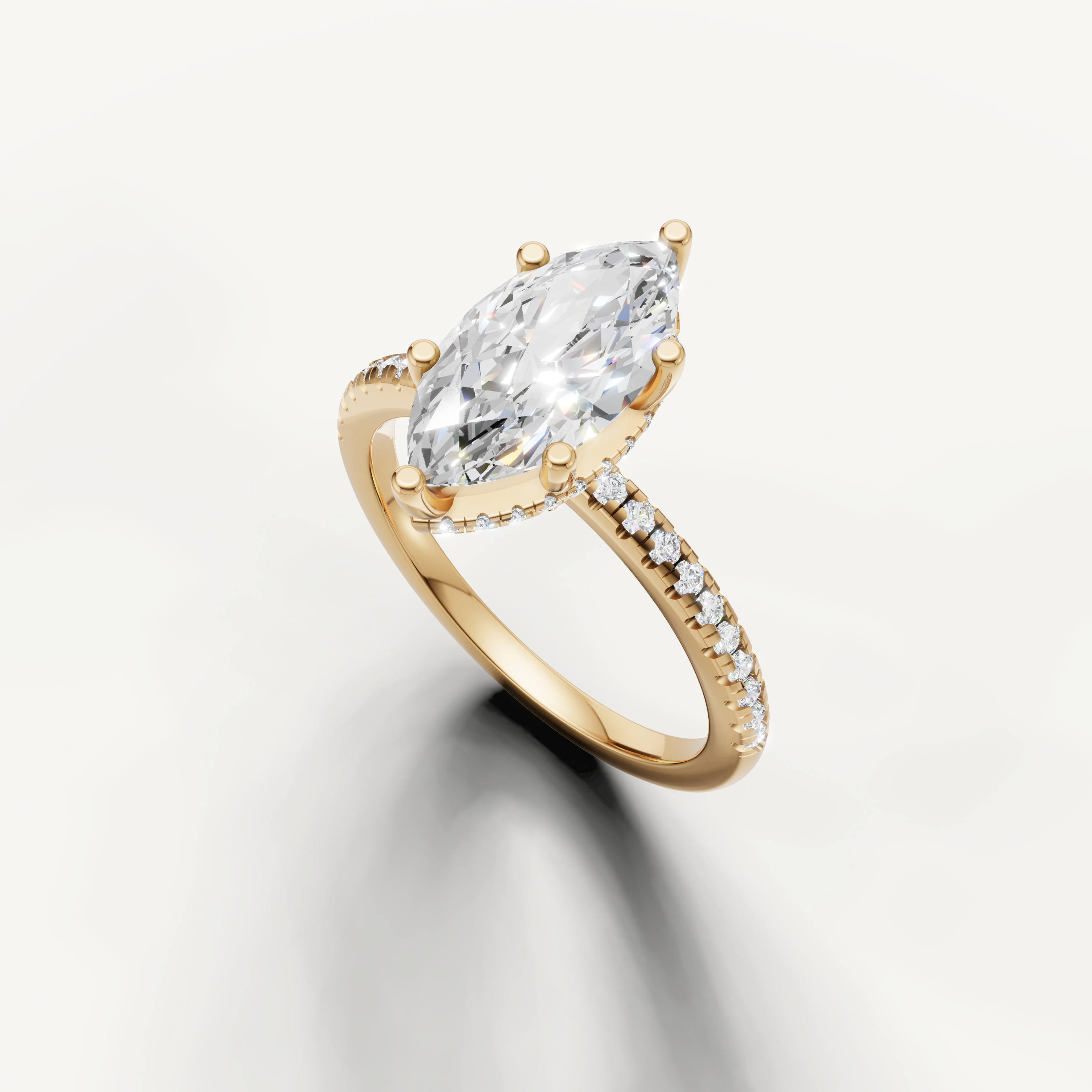 elongated marquise diamond engagement ring with delicate pavé setting in yellow gold