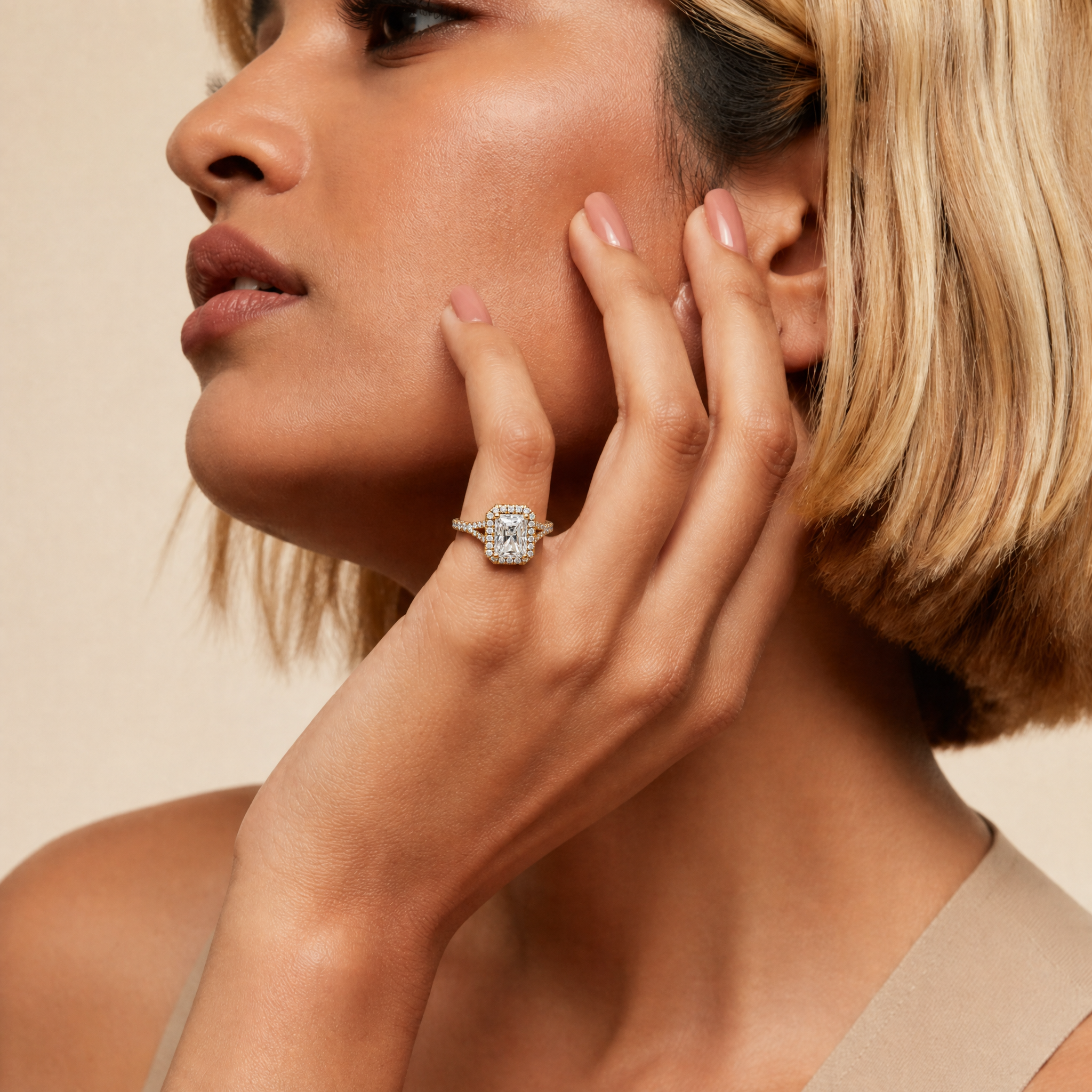A luxury lifestyle photograph of a model wearing a Raul Diamonds radiant cut diamond engagement ring, featuring a brilliant halo and a diamond-encrusted split shank band in a high-polish finish