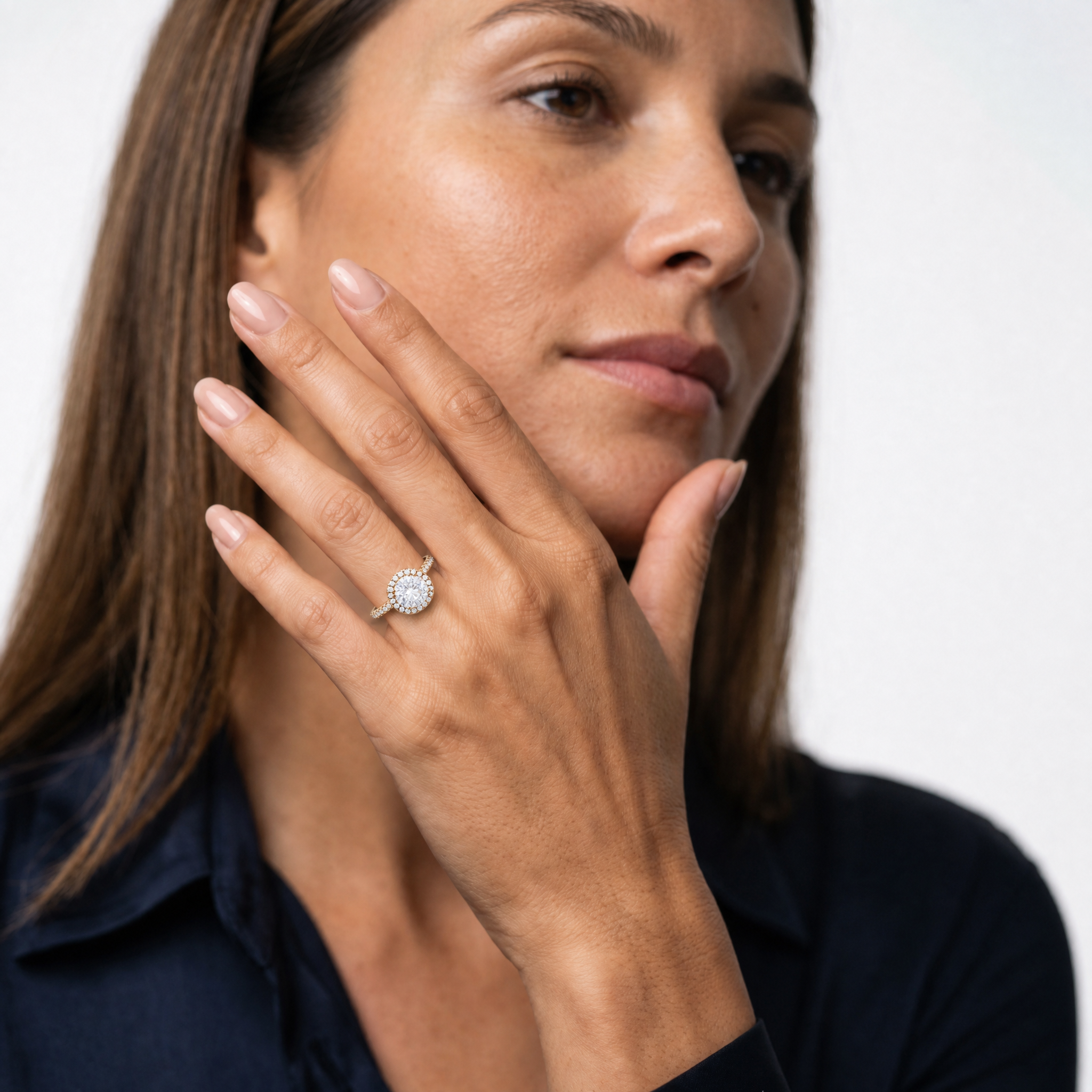 Model wearing a round cut lab grown diamond halo engagement ring in 14K gold by Raul Diamonds