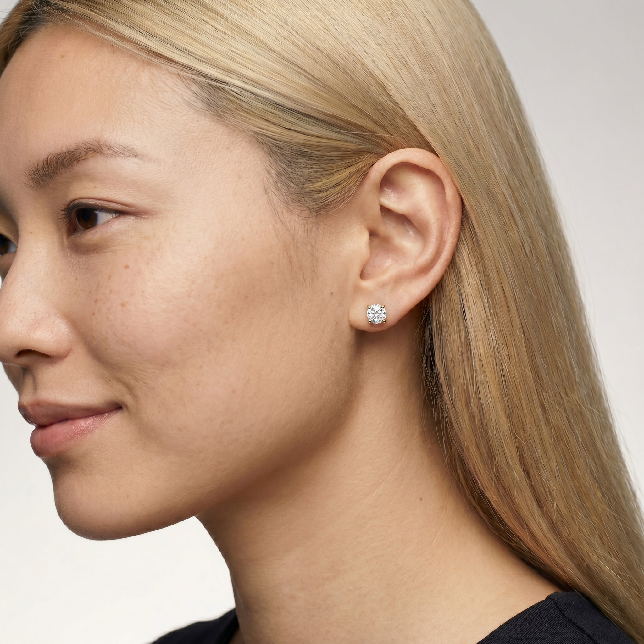 Elegant model wearing Raul Diamonds round diamond stud earrings with timeless solitaire styling