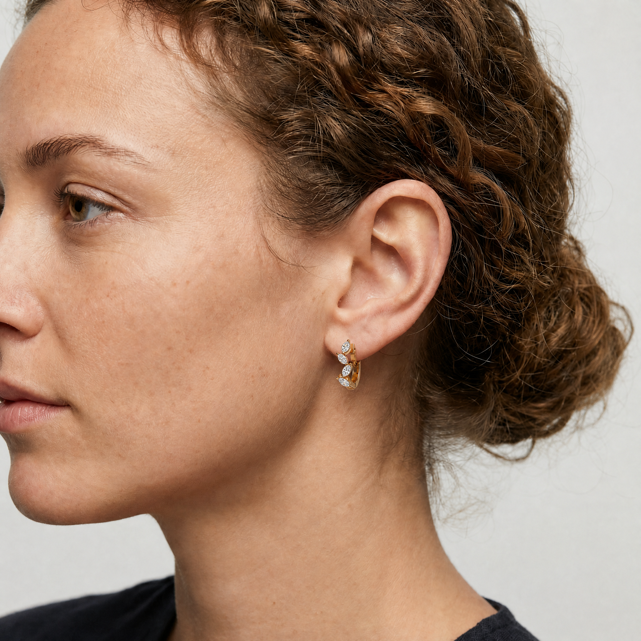 Elegant model wearing Raul Diamonds marquise diamond hoop earrings with luxury sparkle