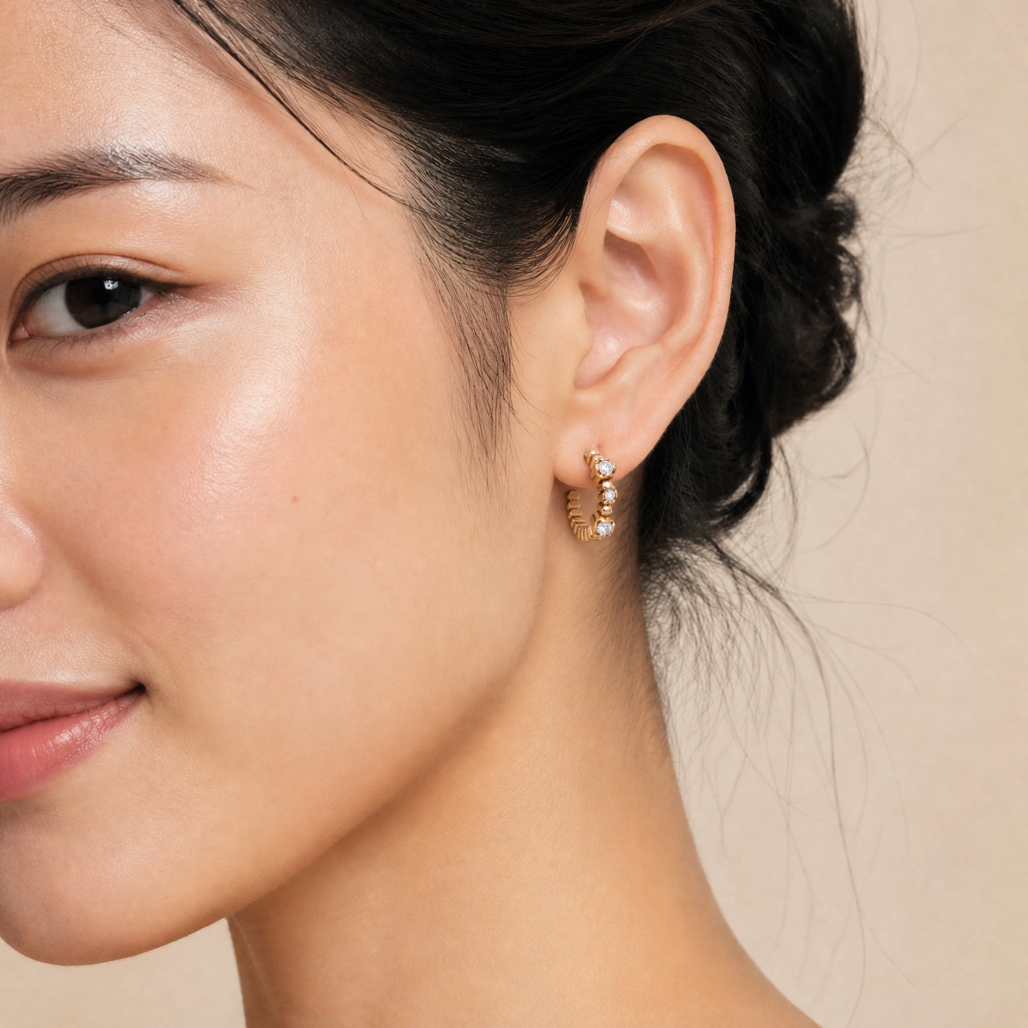 Female model wearing Raul Diamonds bezel set diamond hoop earrings in rose gold