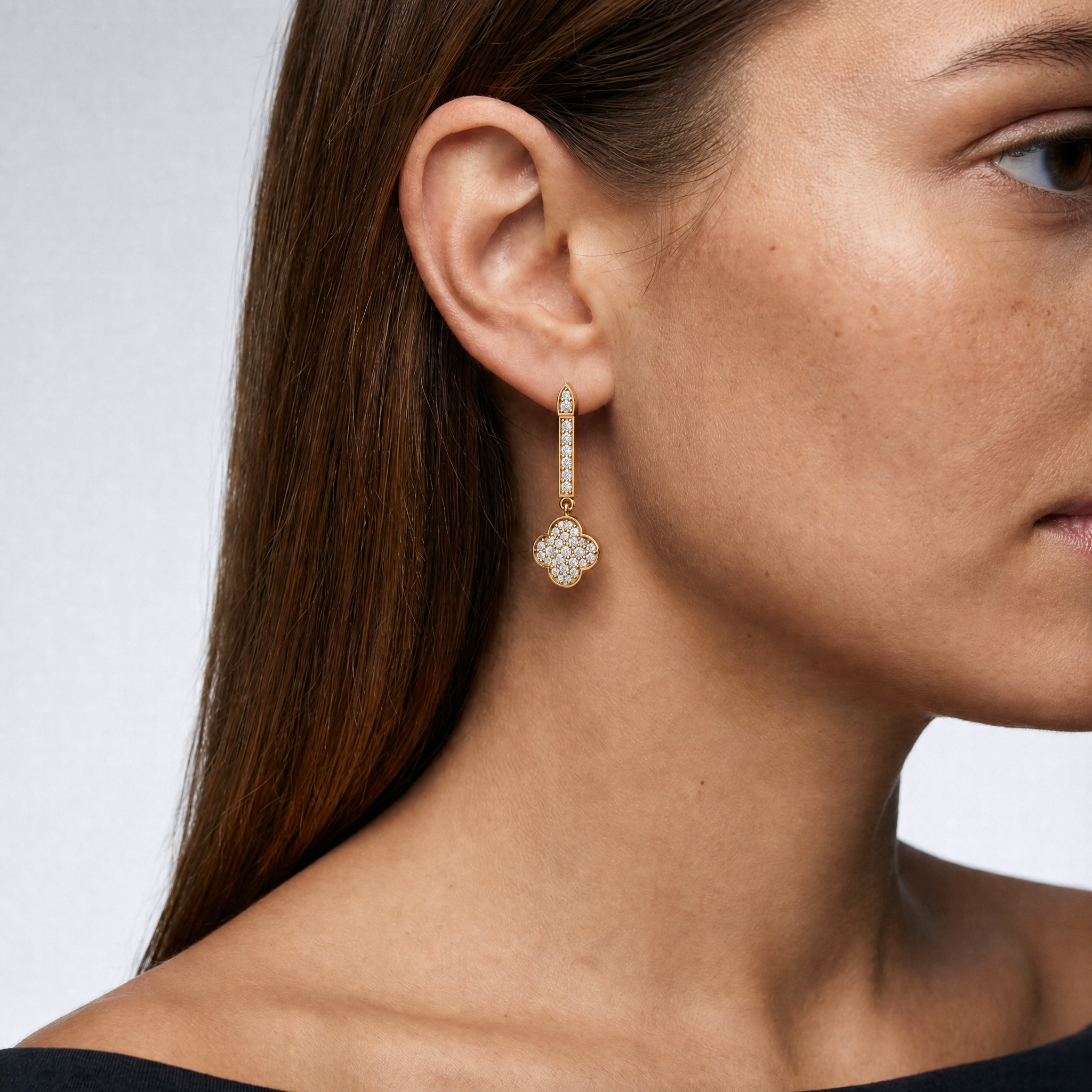 Model wearing Raul Diamonds luxury diamond clover drop earrings in gold finish