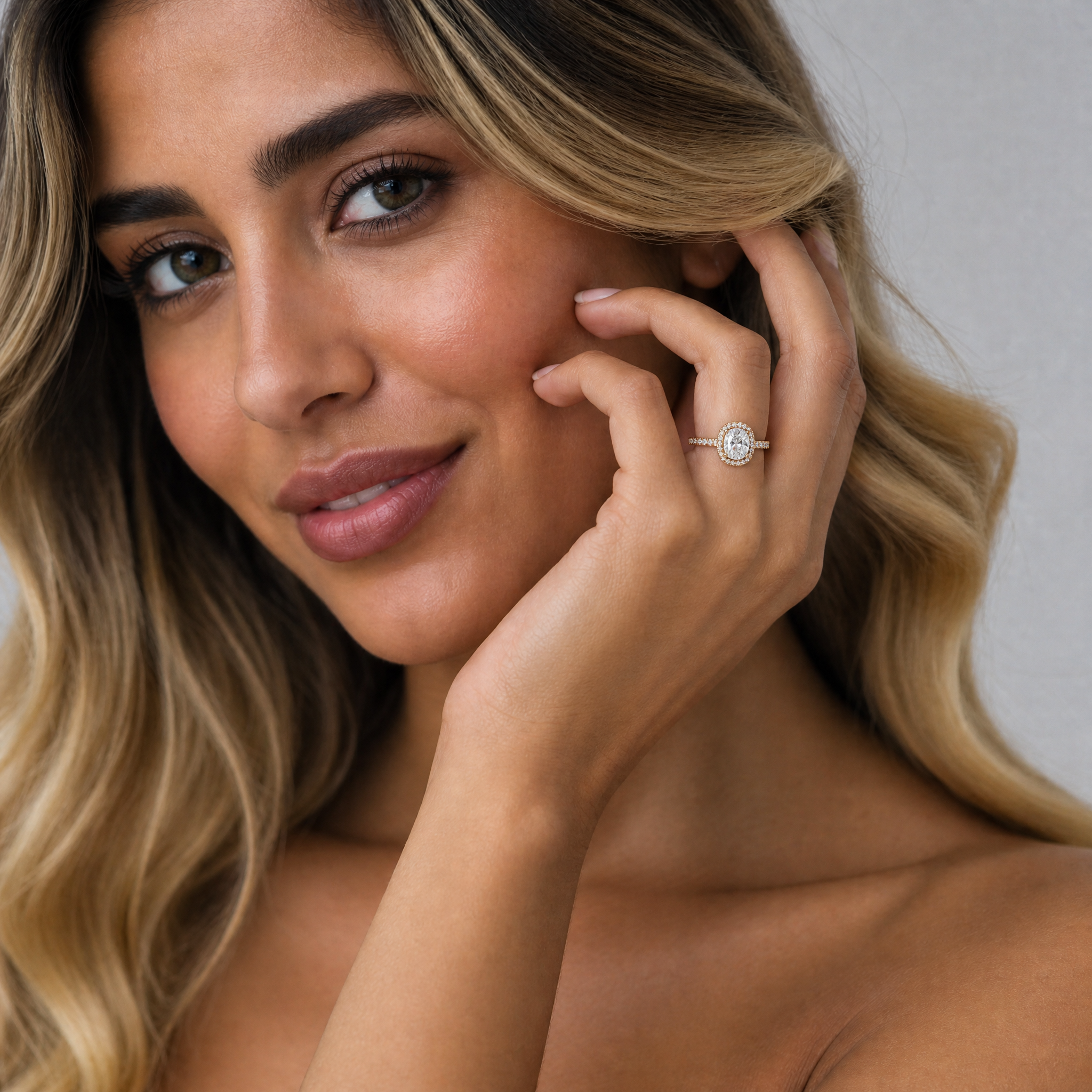Model wearing Raul Diamonds cushion cut halo diamond engagement ring with pavé diamond band in polished gold