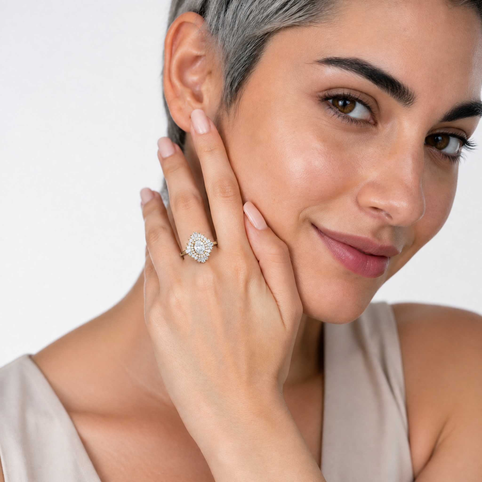 Model wearing Raul Diamonds oval diamond halo engagement ring with baguette accents in yellow gold