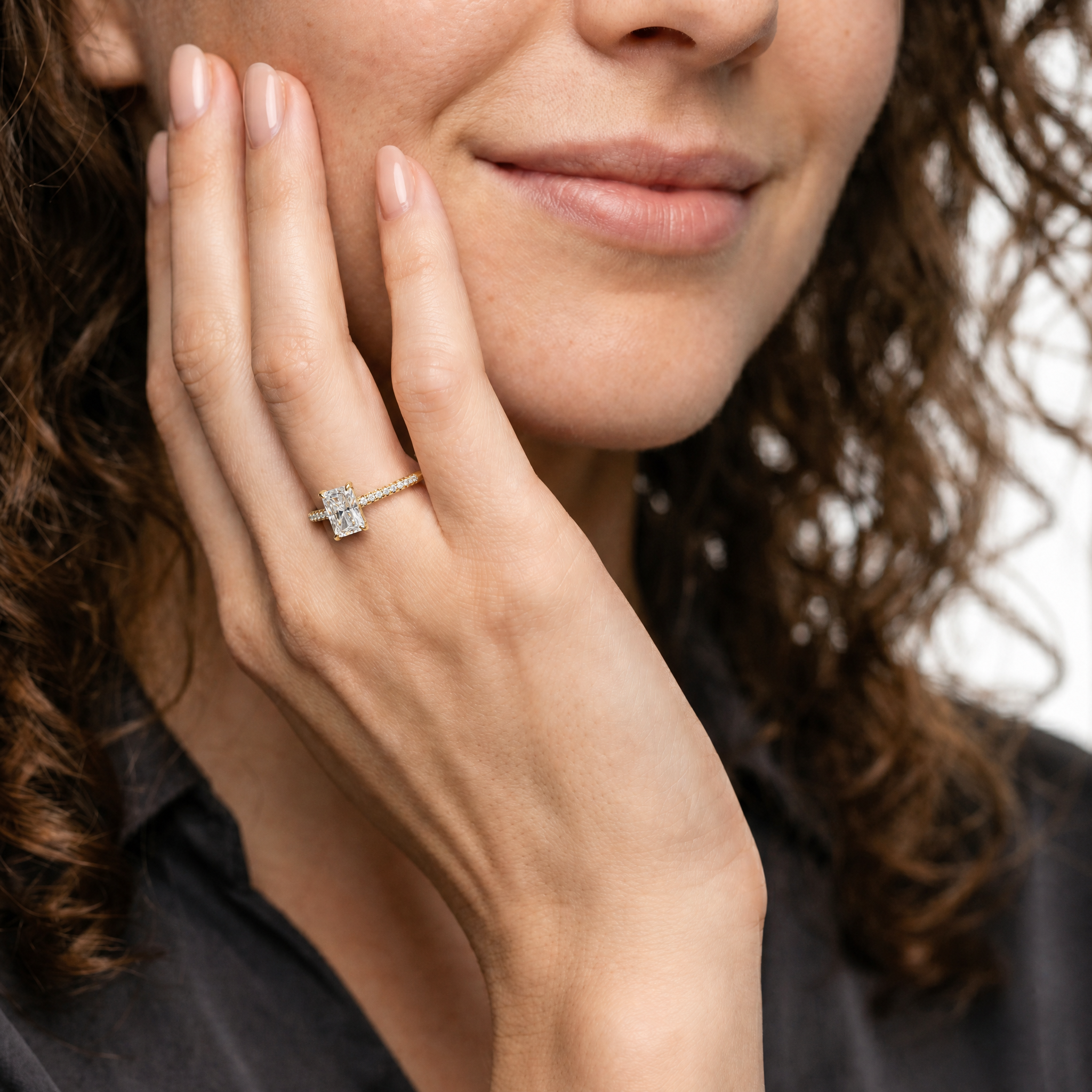 Model Charlotte Evans wearing Raul Diamonds radiant cut yellow gold engagement ring with pavé diamond band and luxury bridal styling