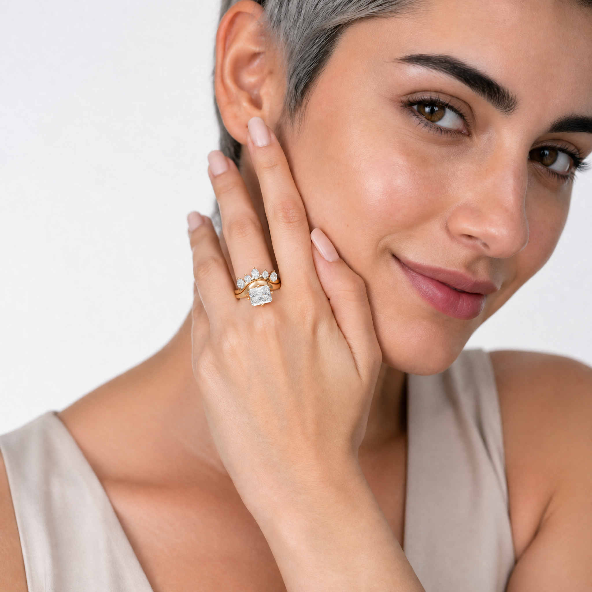 Elegant model wearing Raul Diamonds radiant cut diamond bridal set with crown inspired curved wedding band