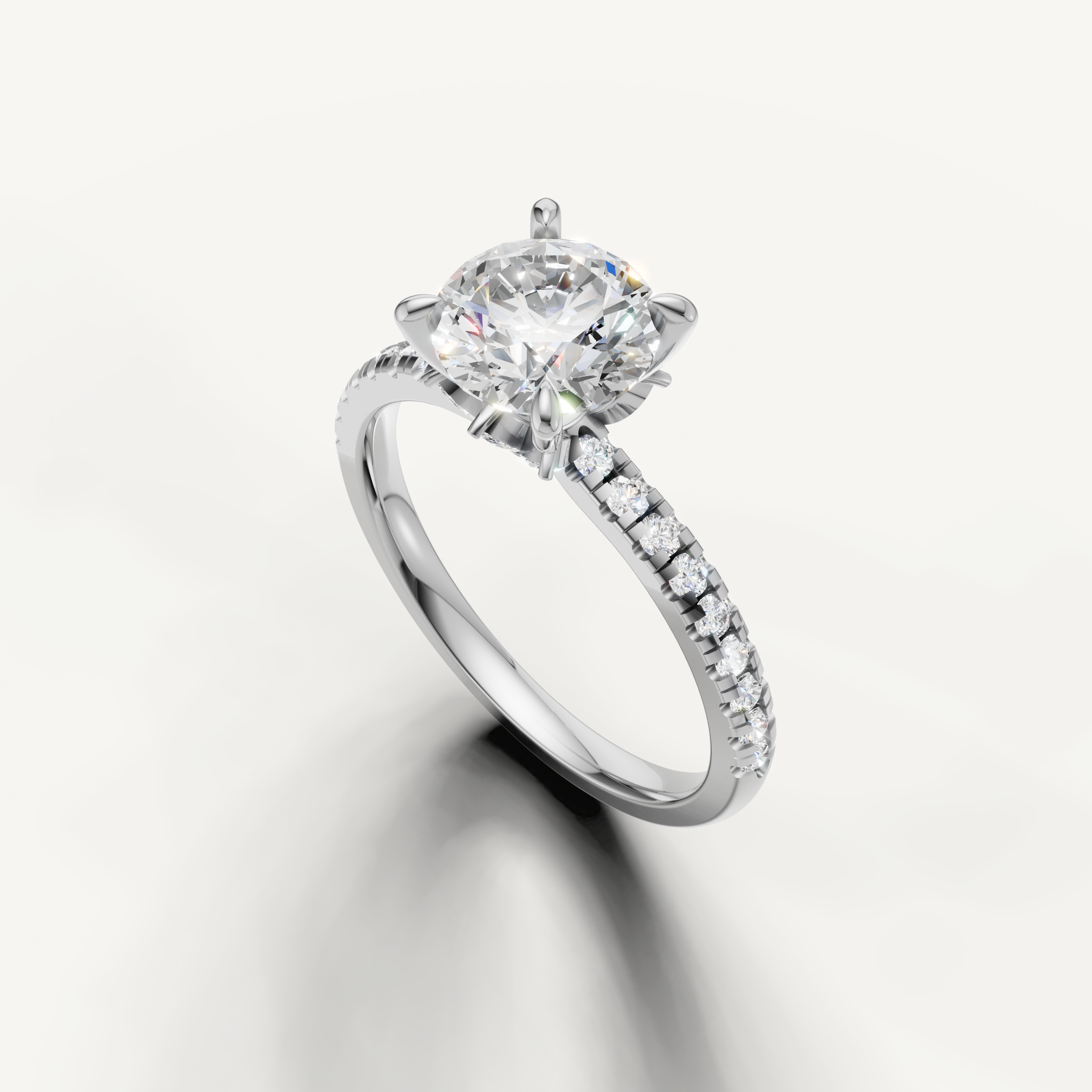 Icy white gold round cut solitaire ring with a pavé-set diamond band, perfect for a sophisticated proposal.