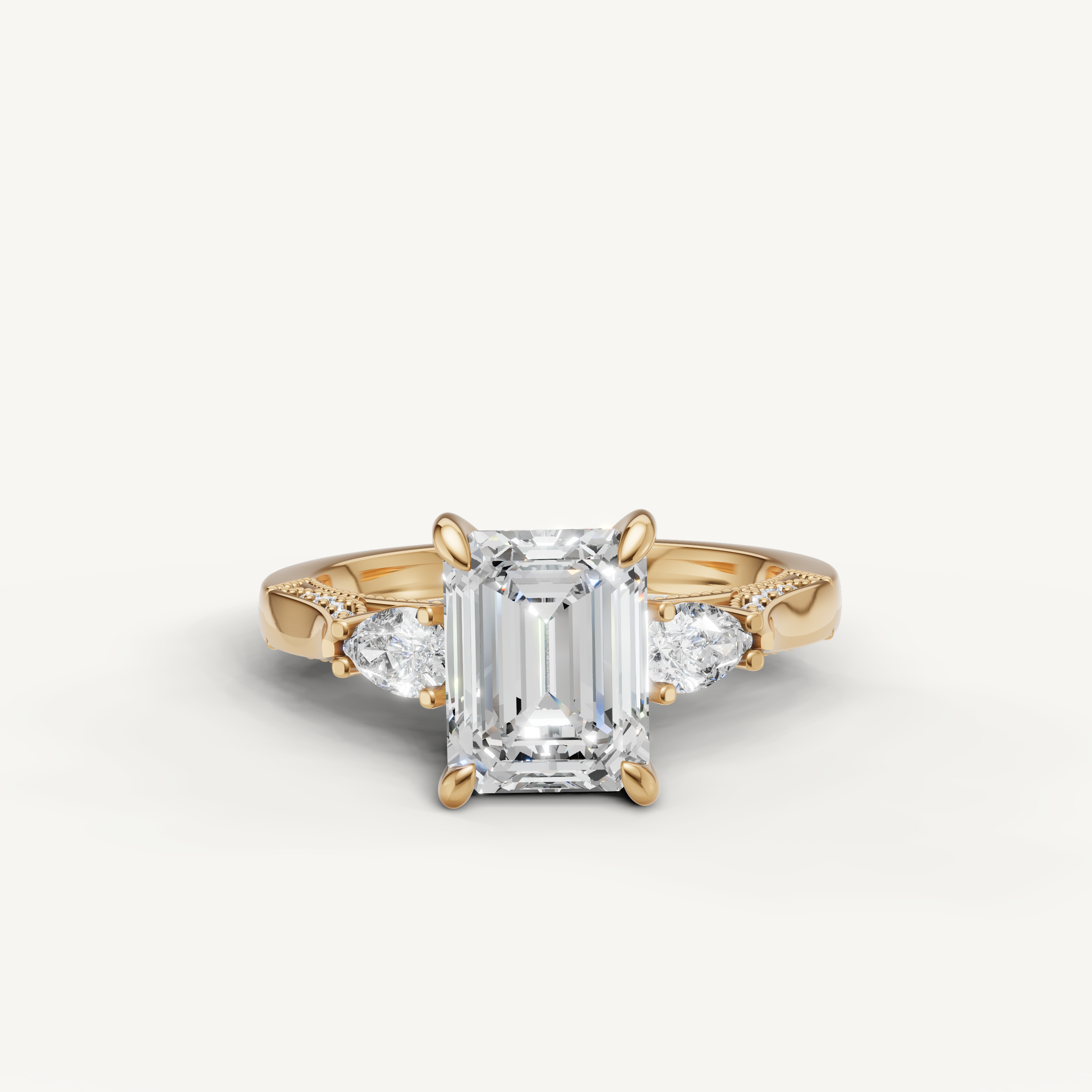 Emerald cut lab grown diamond three stone ring with pear side stones yellow gold engagement ring