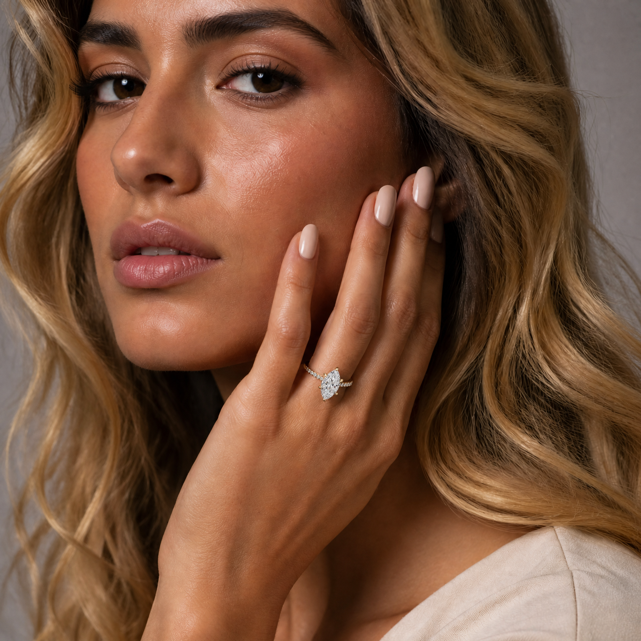 Model wearing Raul Diamonds marquise cut lab grown diamond engagement ring in 14K yellow gold with pavé band and elegant solitaire setting