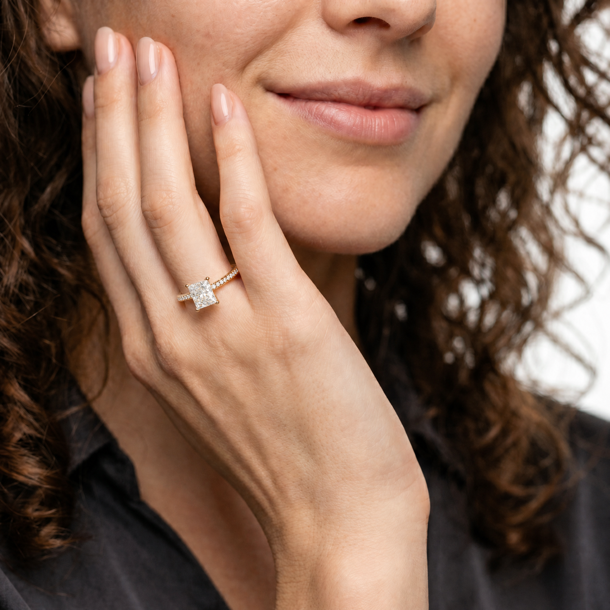 Model wearing a princess cut lab grown diamond engagement ring with pavé band in 14K gold by Raul Diamonds