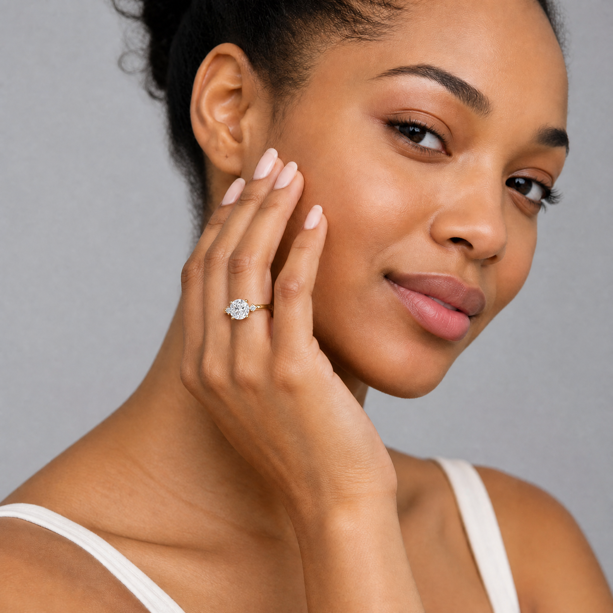 Model wearing Raul Diamonds round cut lab grown diamond engagement ring in 14K yellow gold with round side stones