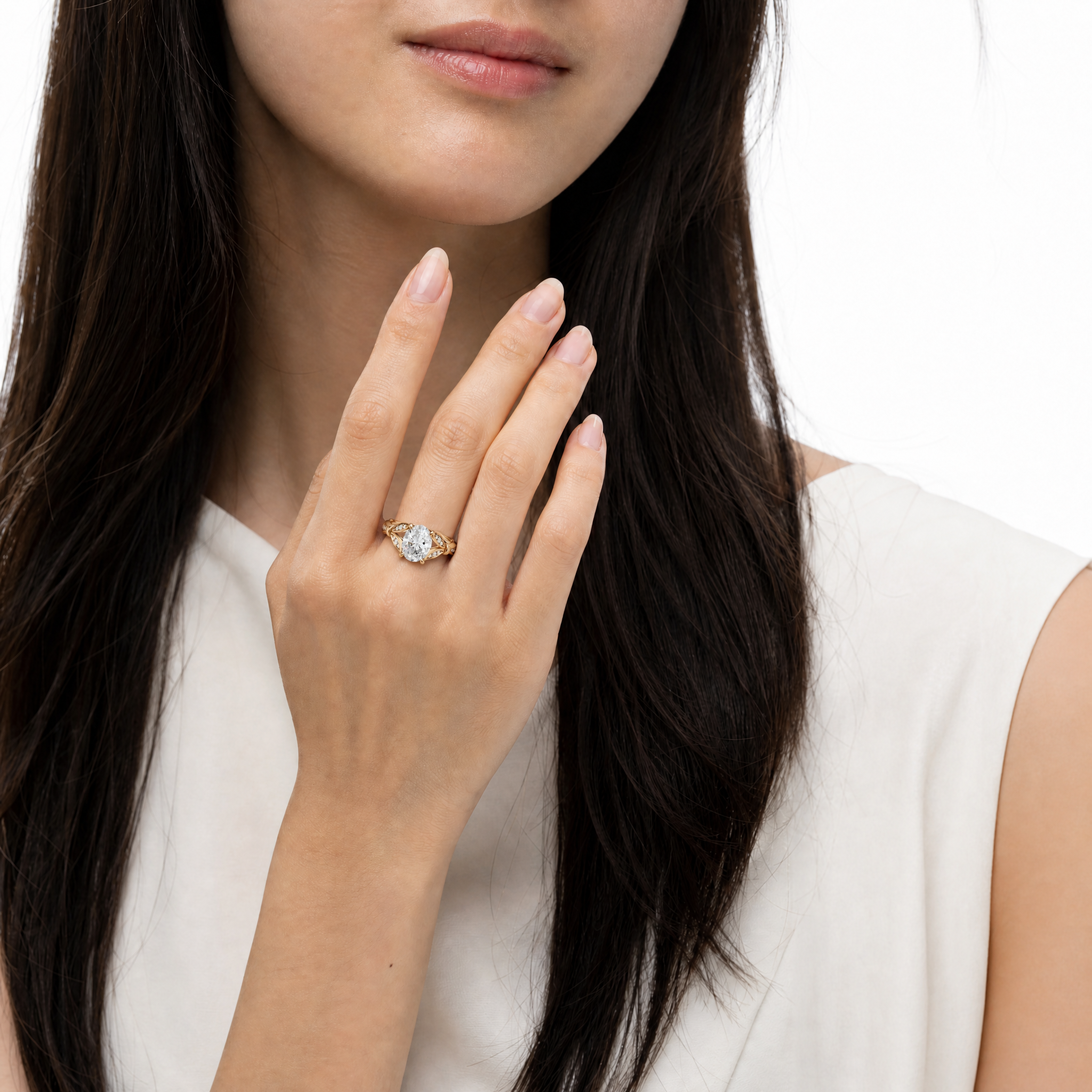 Model wearing Raul Diamonds oval cut lab grown diamond engagement ring in 14K gold with elegant pavé detailing