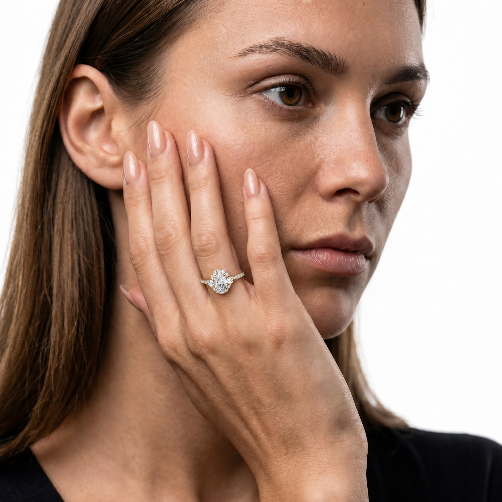 Model wearing Raul Diamonds oval halo diamond engagement ring in yellow gold with pavé diamond band