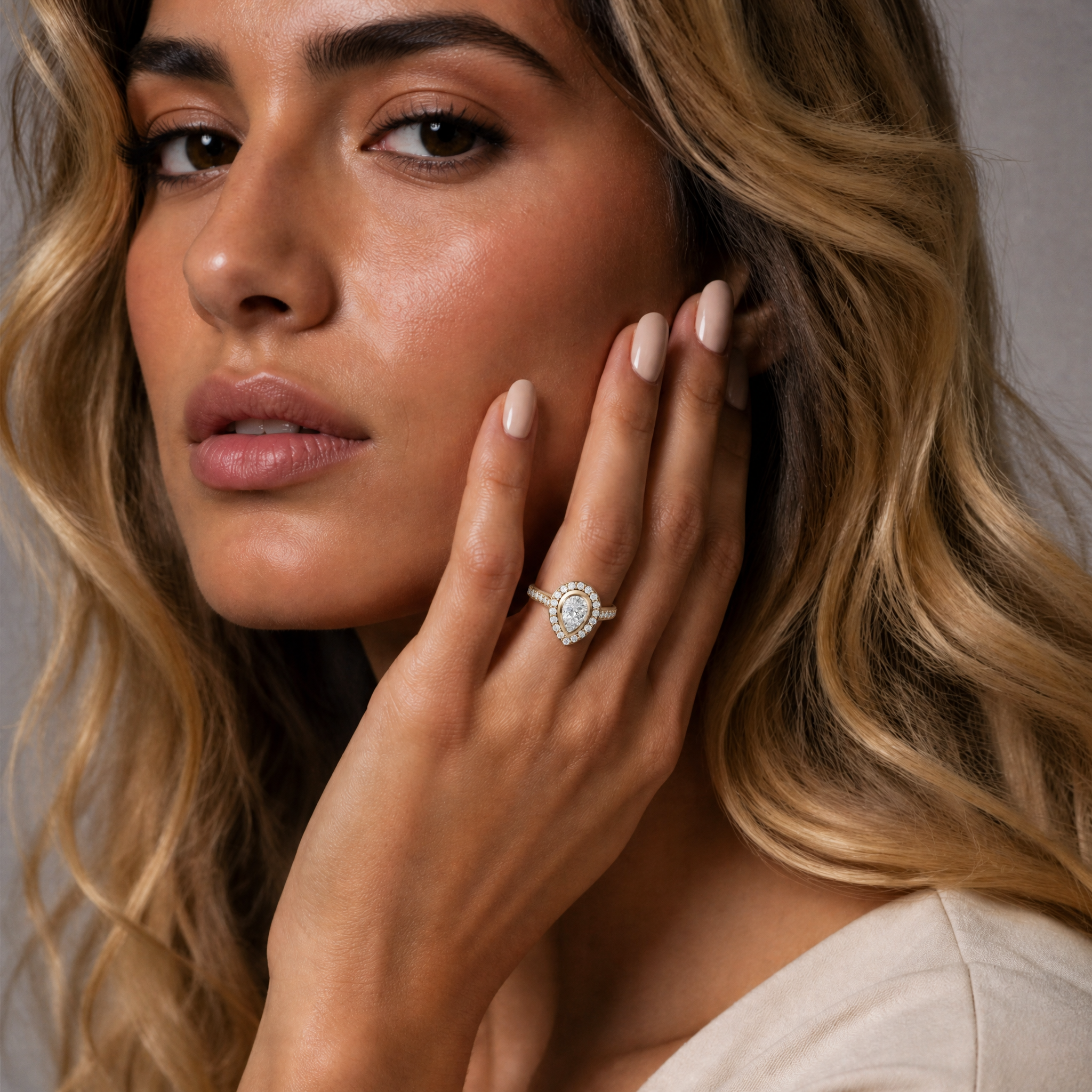 Model wearing Raul Diamonds pear halo diamond engagement ring in yellow gold with pavé diamond band