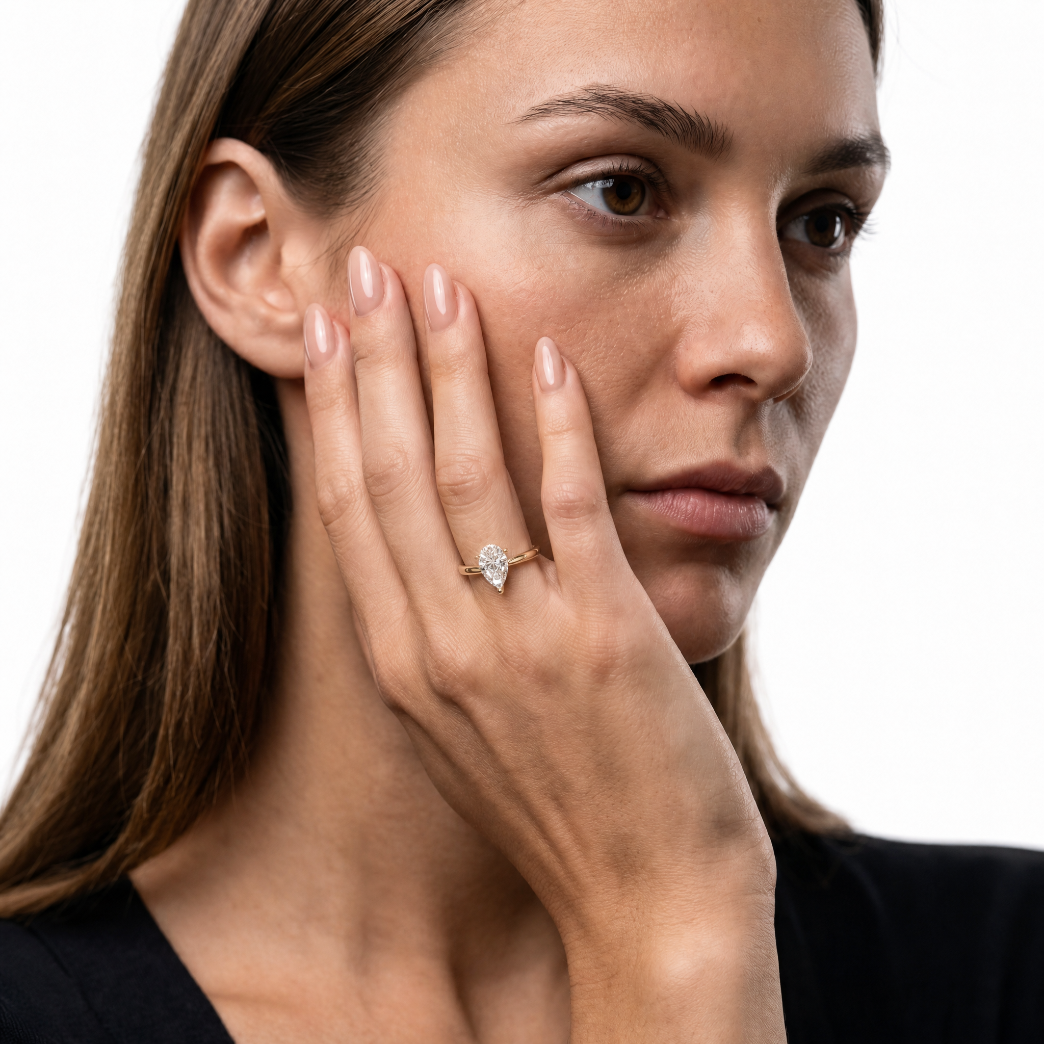 Elegant model wearing a pear-shaped lab-grown diamond engagement ring in 14K gold with hidden halo by Raul Diamonds
