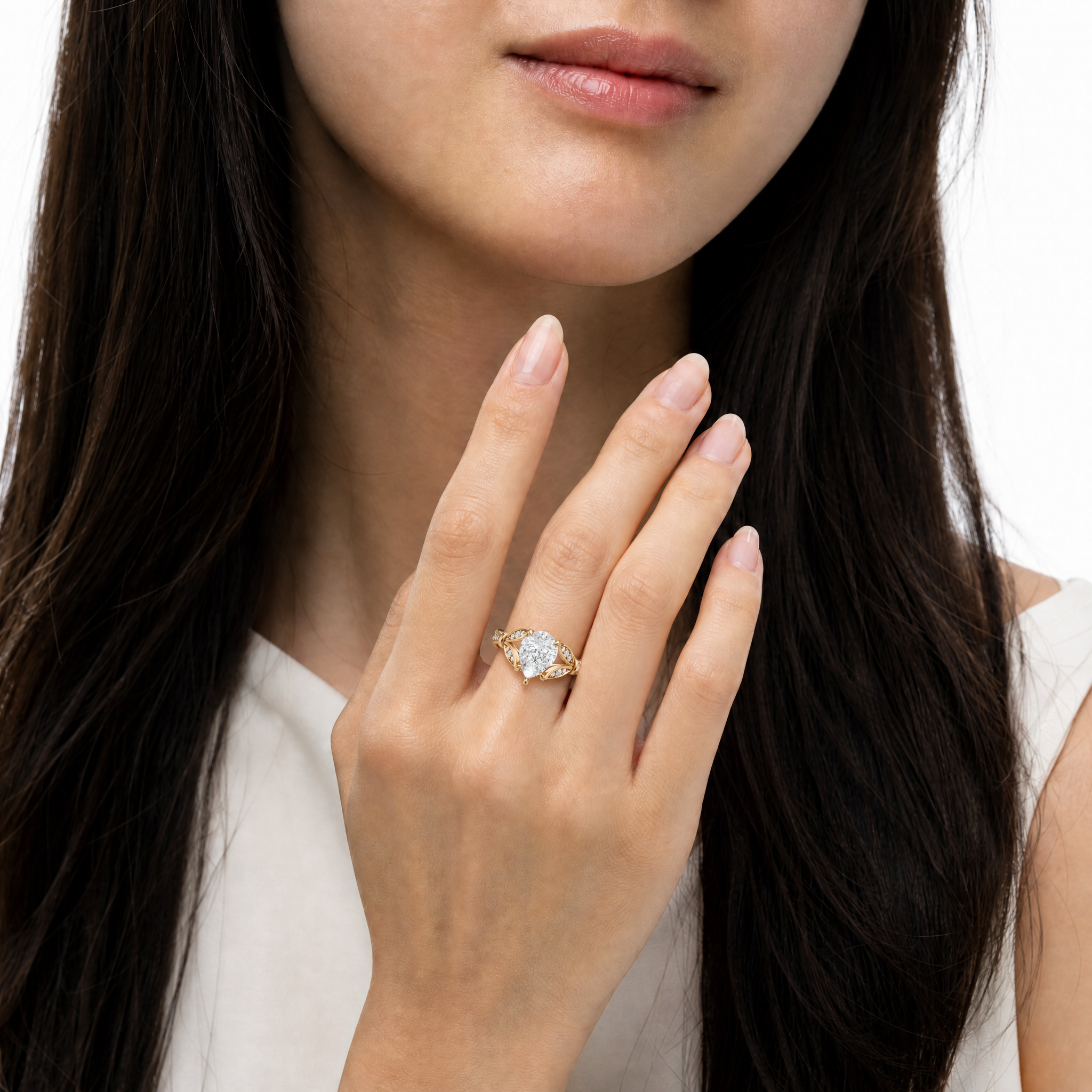 Model wearing Raul Diamonds pear cut lab grown diamond engagement ring in 14K gold with elegant pavé detailing