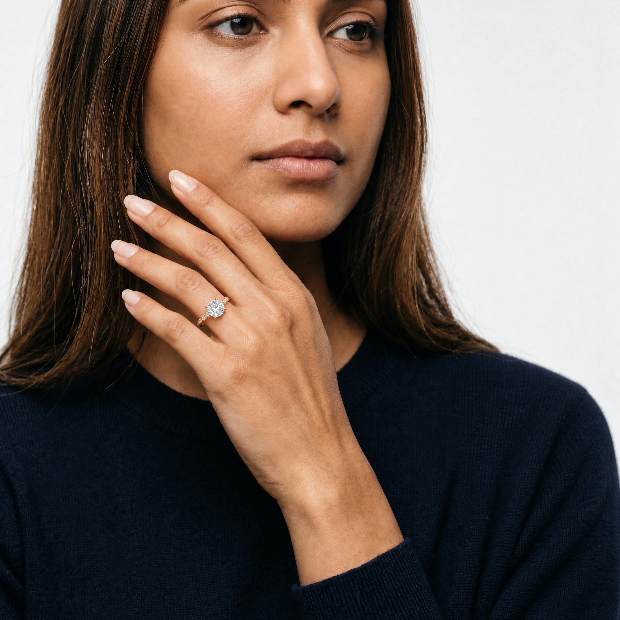 Model wearing round cut lab grown diamond engagement ring in 14K gold with marquise side stones by Raul Diamonds