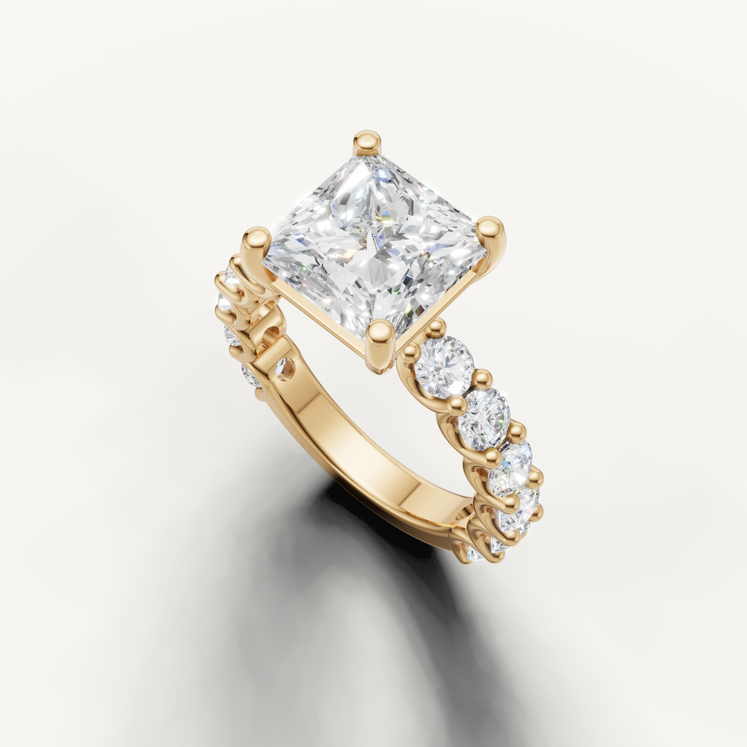 Square princess cut diamond ring with graduated side stones in yellow gold