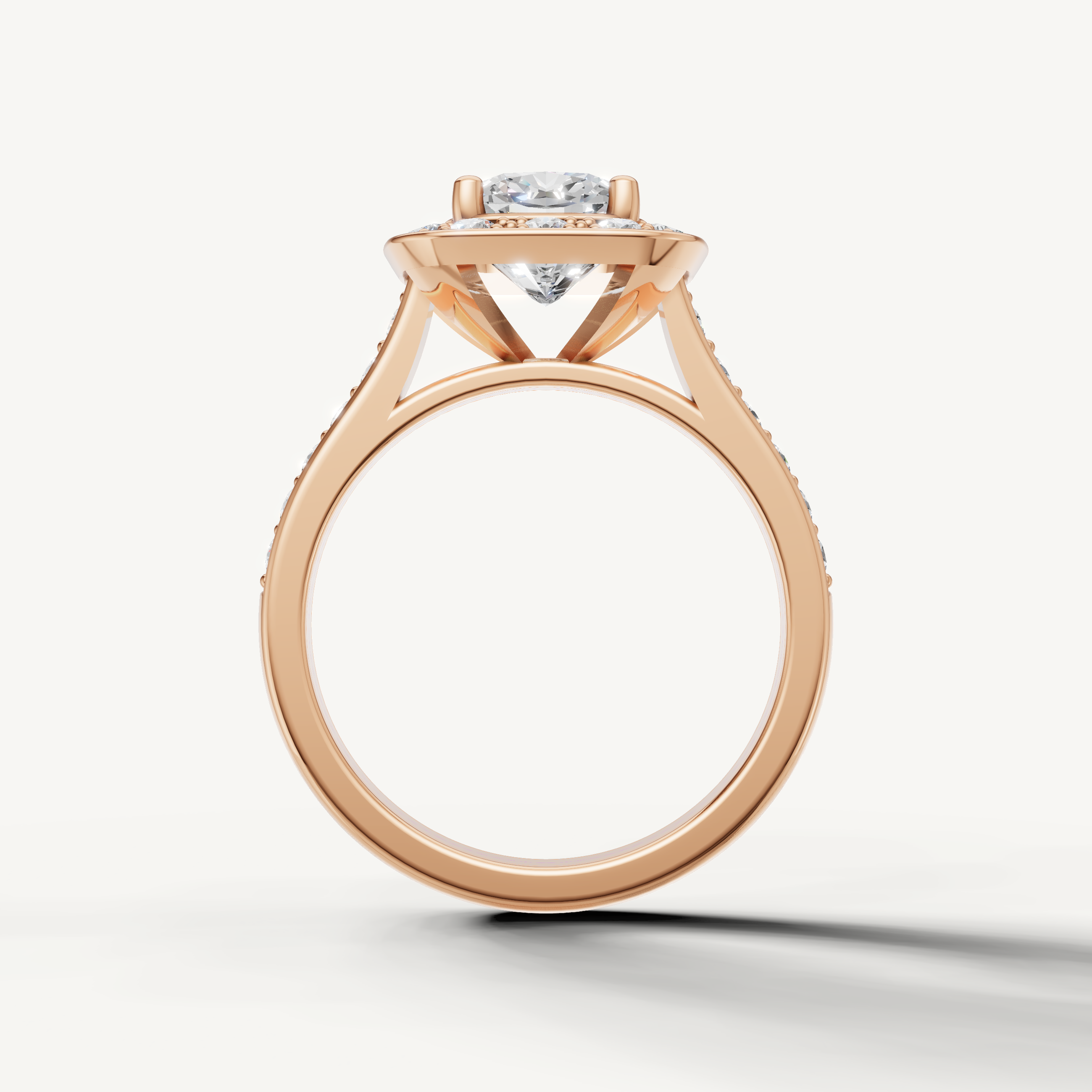 Cushion halo engagement ring in rose gold featuring pave diamonds from Raul Diamonds.