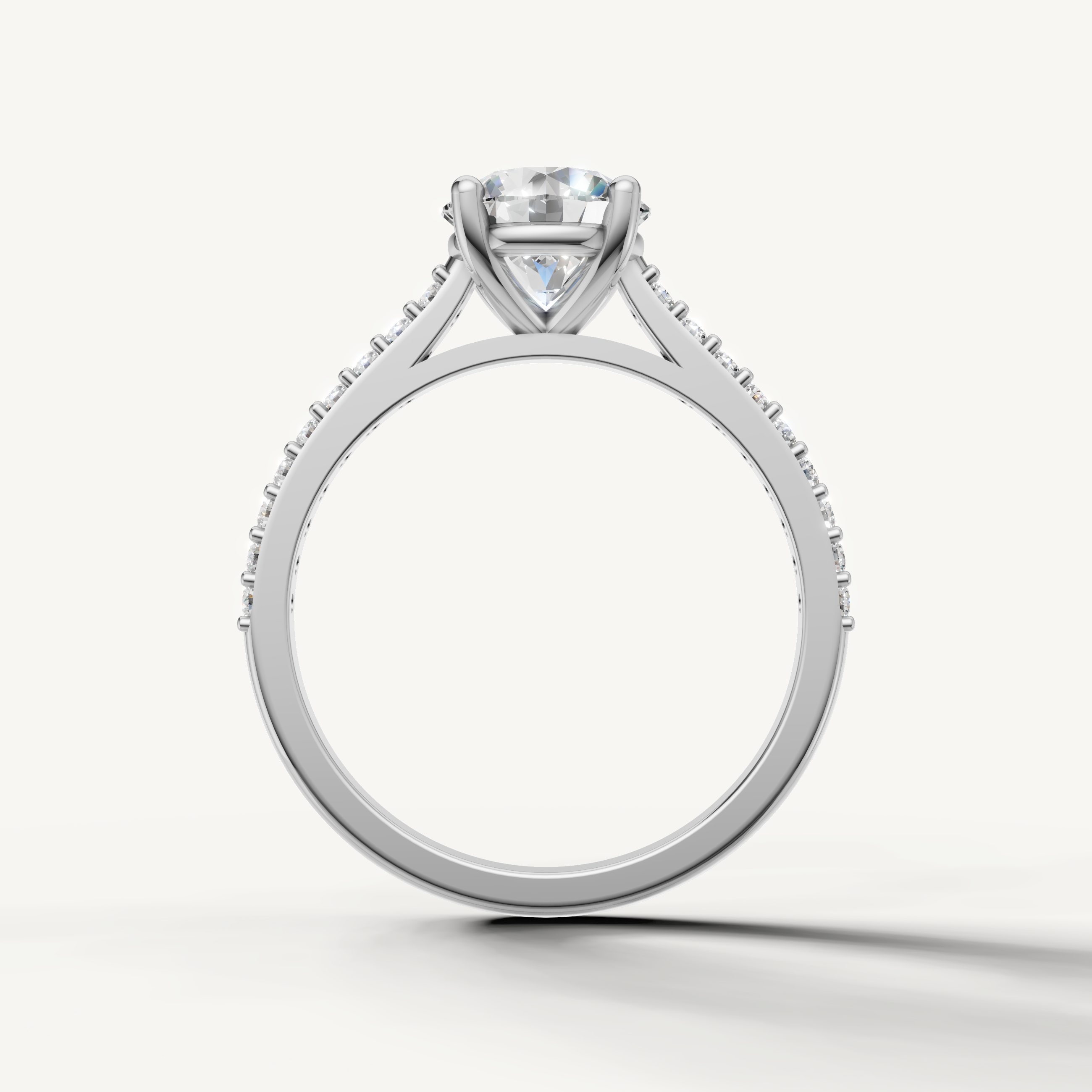 Premium white gold round solitaire engagement ring with pavé band by Raul Diamonds.