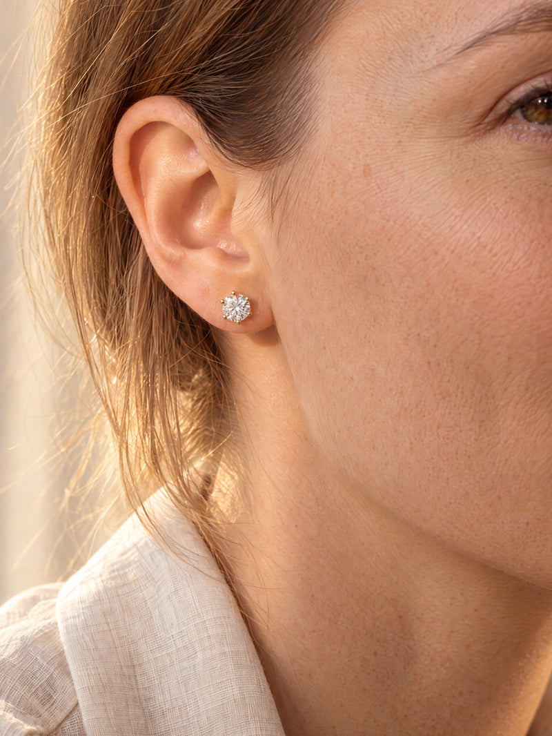 Woman wearing a round lab-grown diamond six-prong stud earring