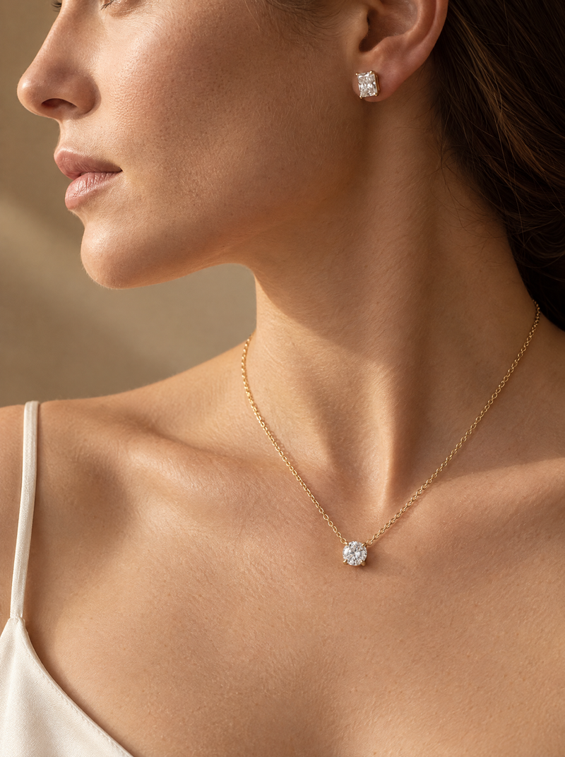 Woman wearing a round lab-grown diamond solitaire pendant in yellow gold