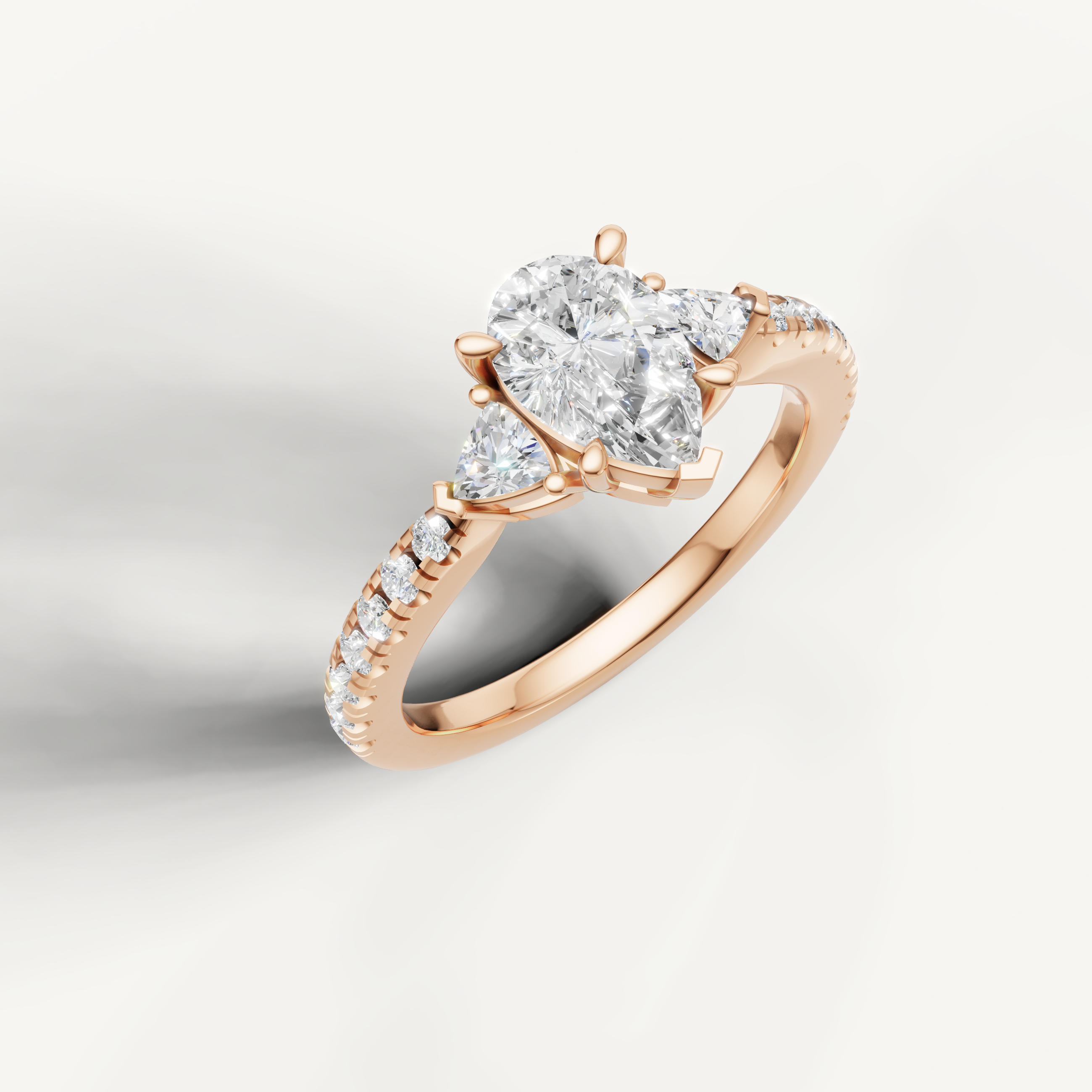 14K rose gold pear shape lab grown diamond ring with three-stone design and pavé setting