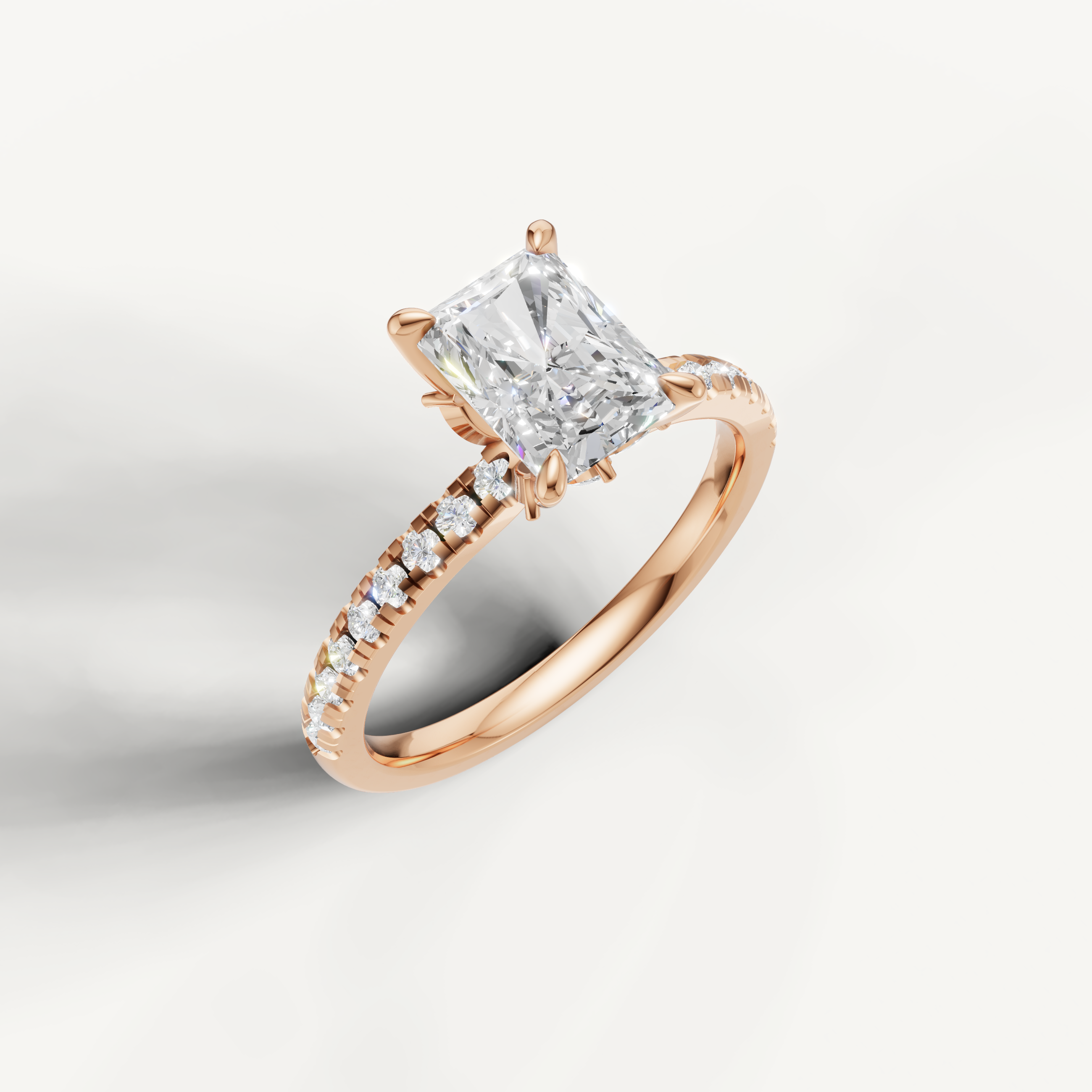Rose gold radiant diamond engagement ring by Raul Diamonds featuring a hidden halo and brilliant-cut side diamonds.